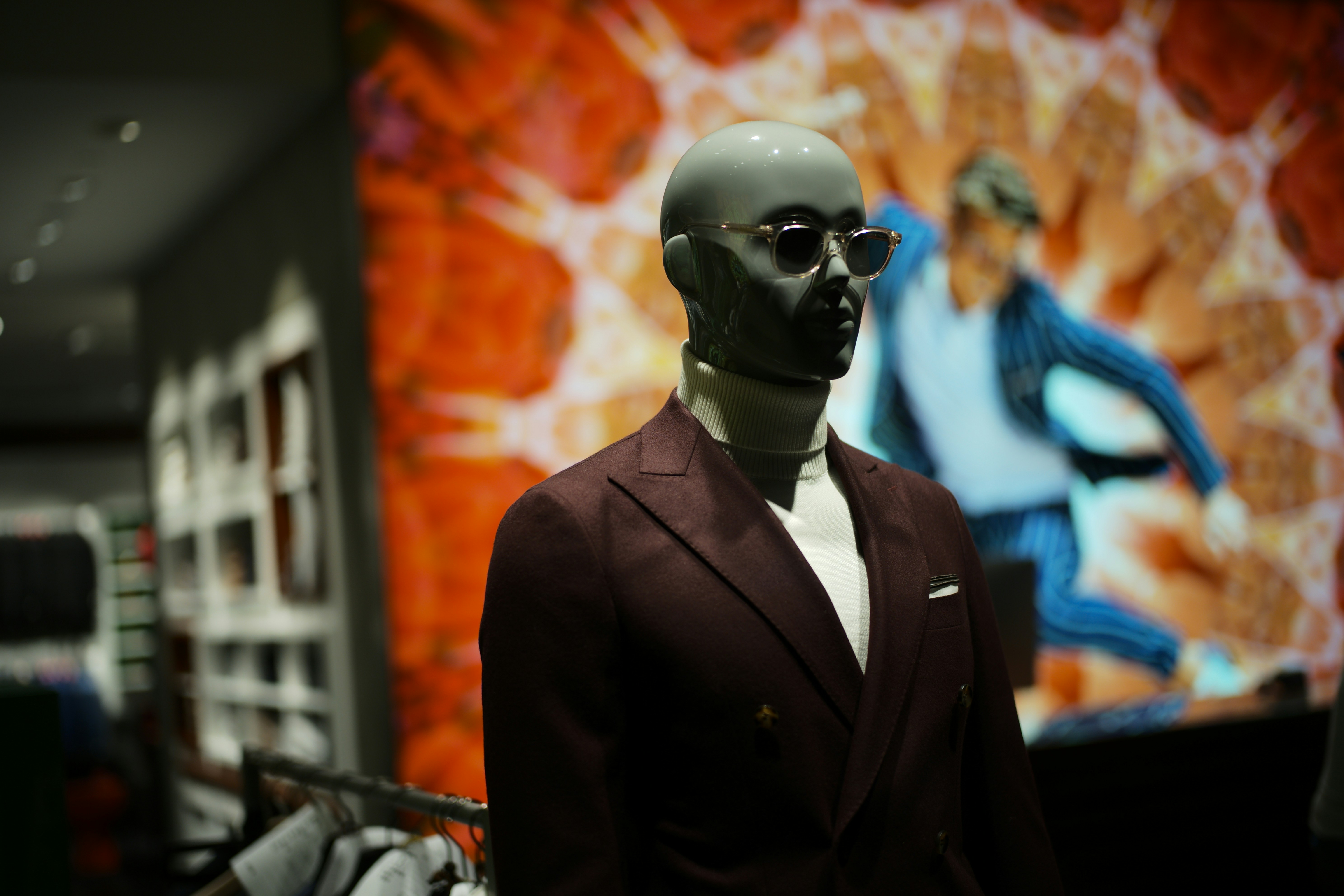 Mannequin wearing a burgundy suit and sunglasses