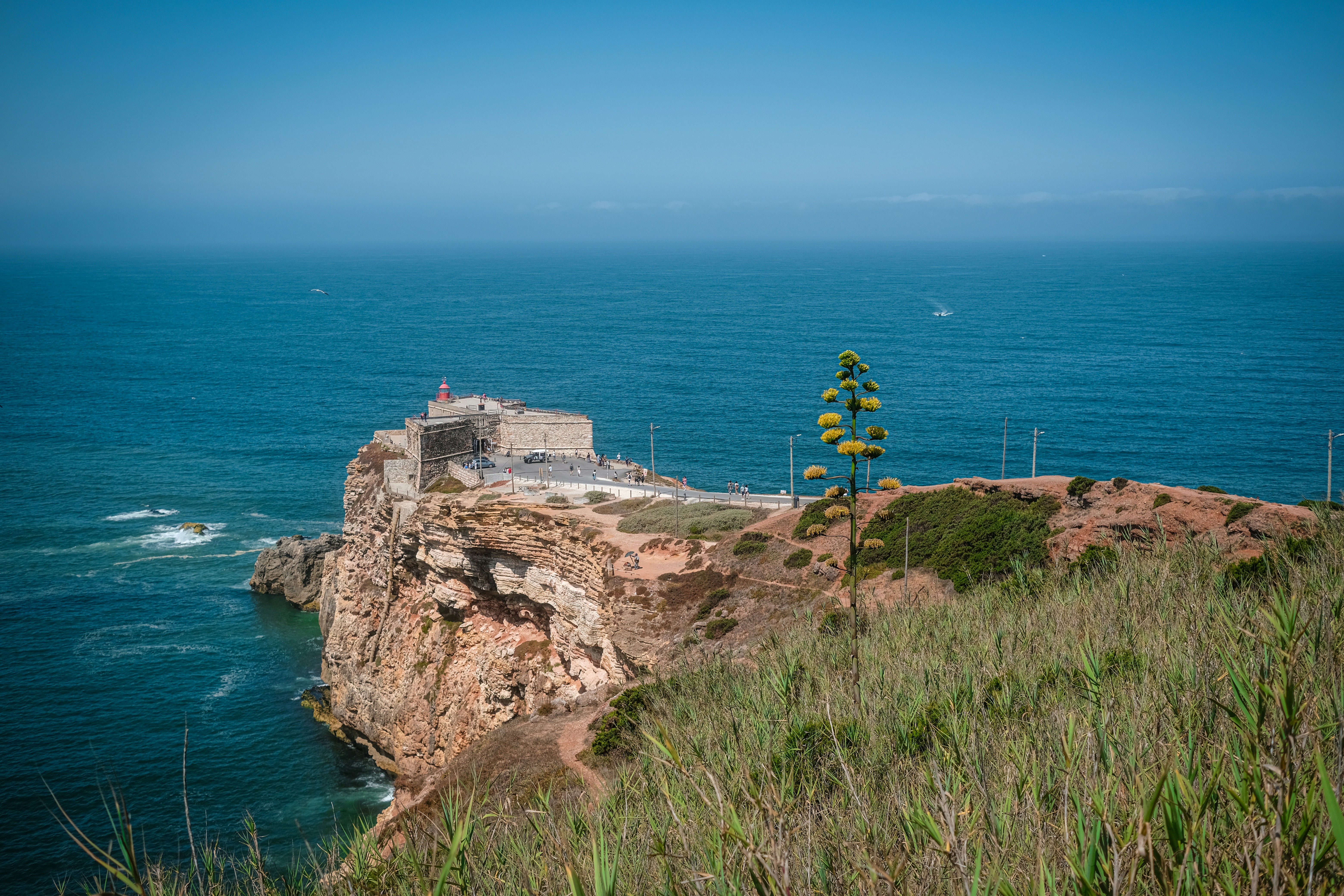 Eine Festung an einer Klippe überblickt den weiten blauen Ozean.