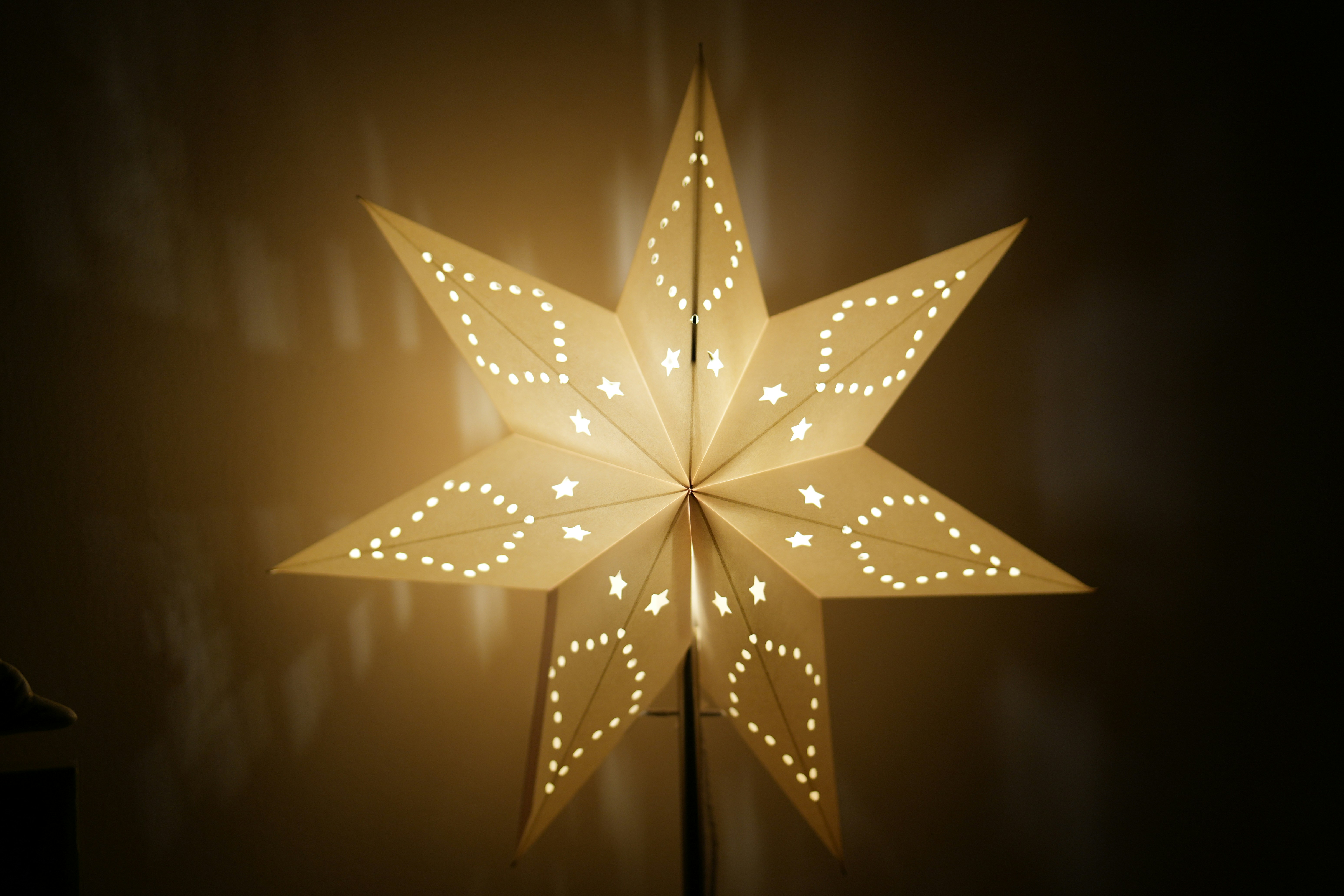 A lit paper star lantern glows warmly.
