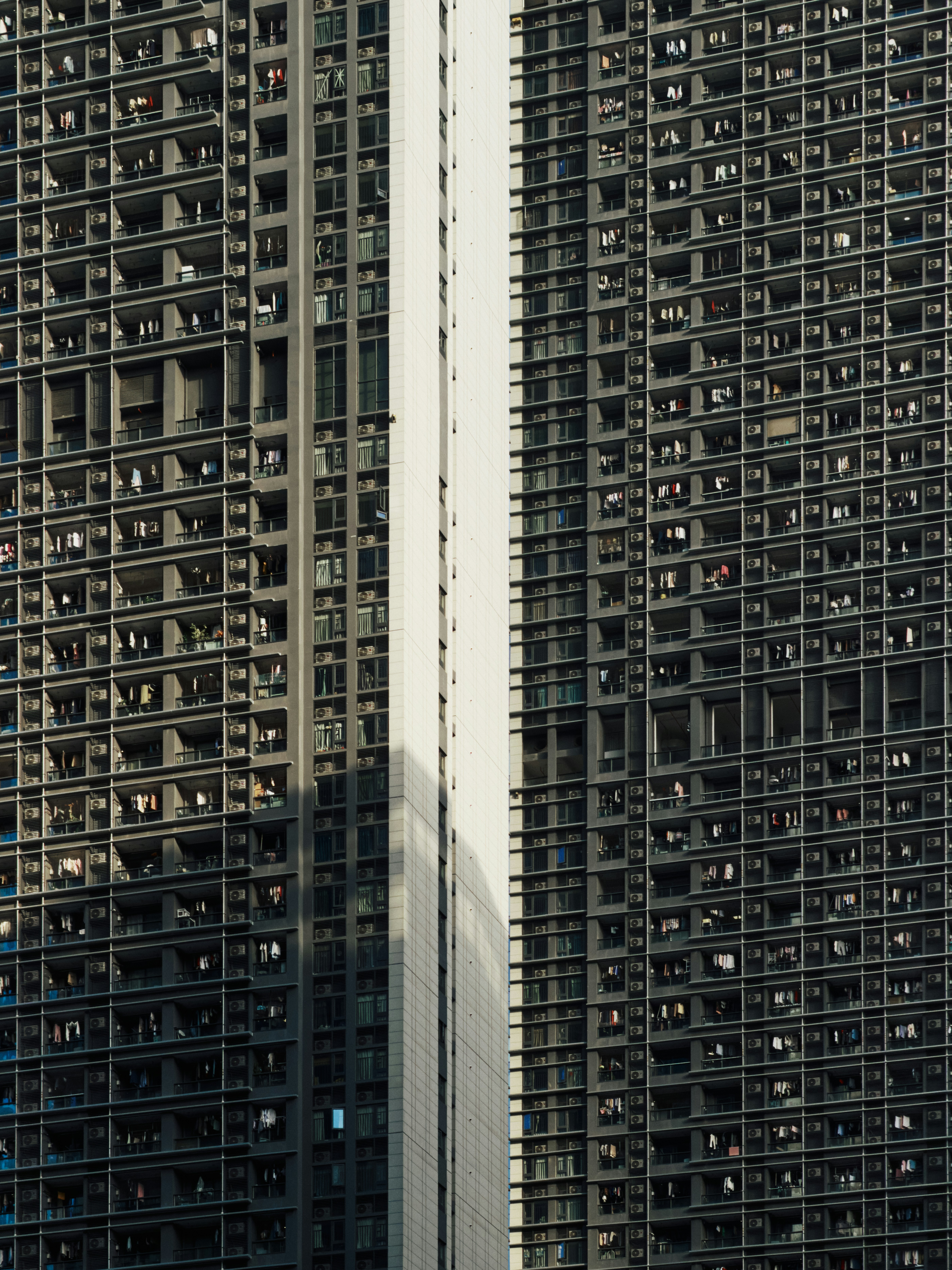 Two tall apartment buildings with many windows.