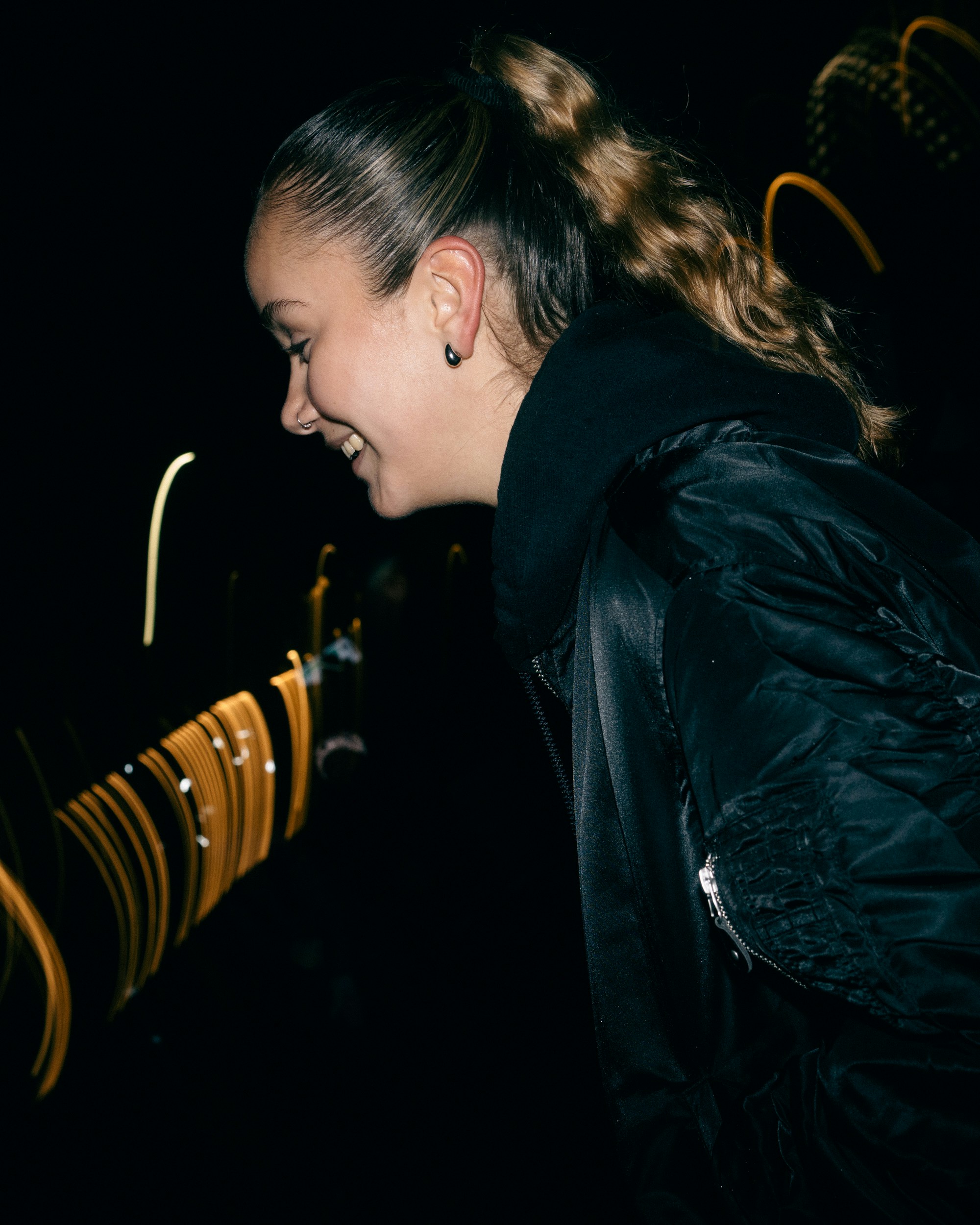 Young woman laughing at night with blurred lights