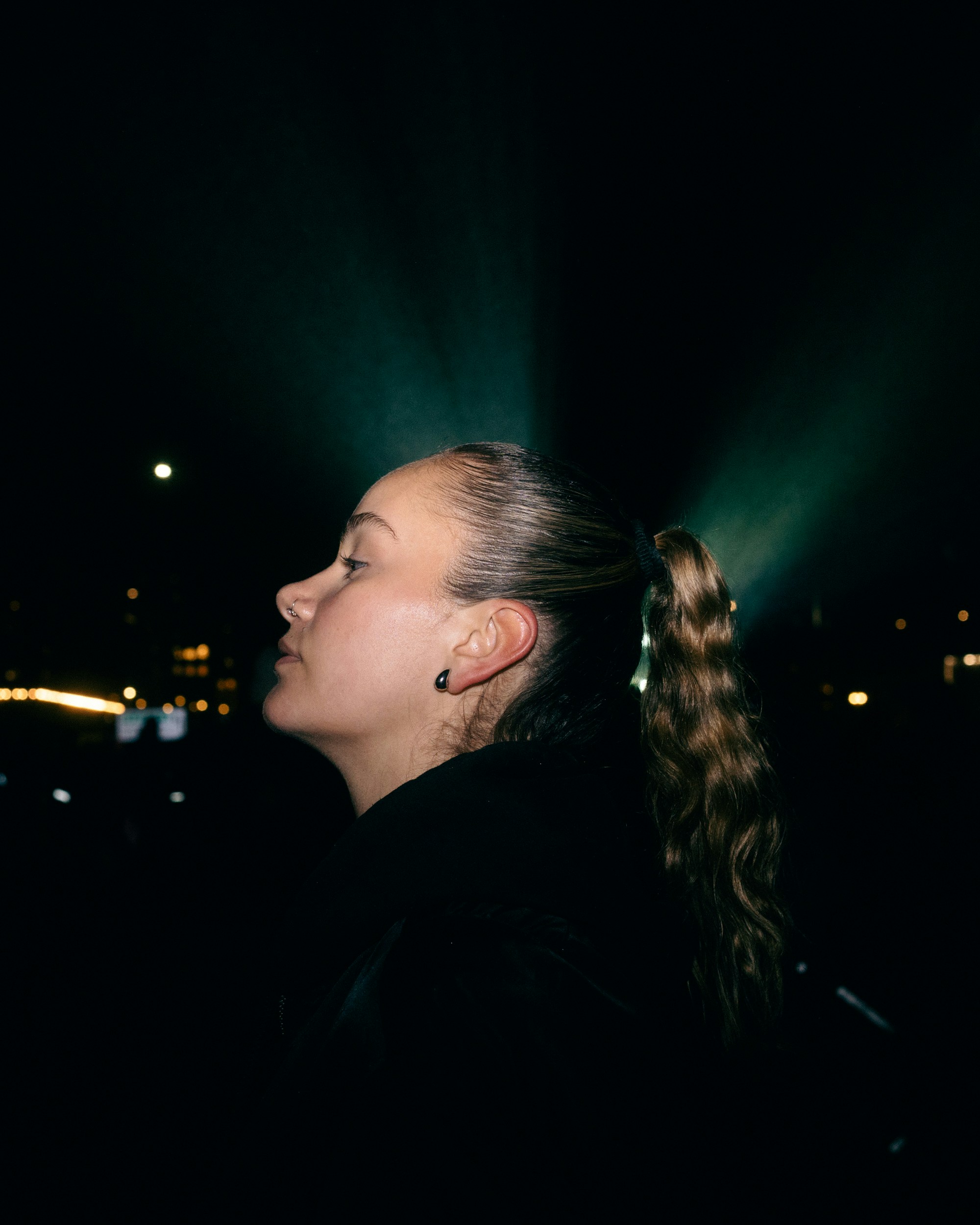 Young woman with ponytail at night with lights