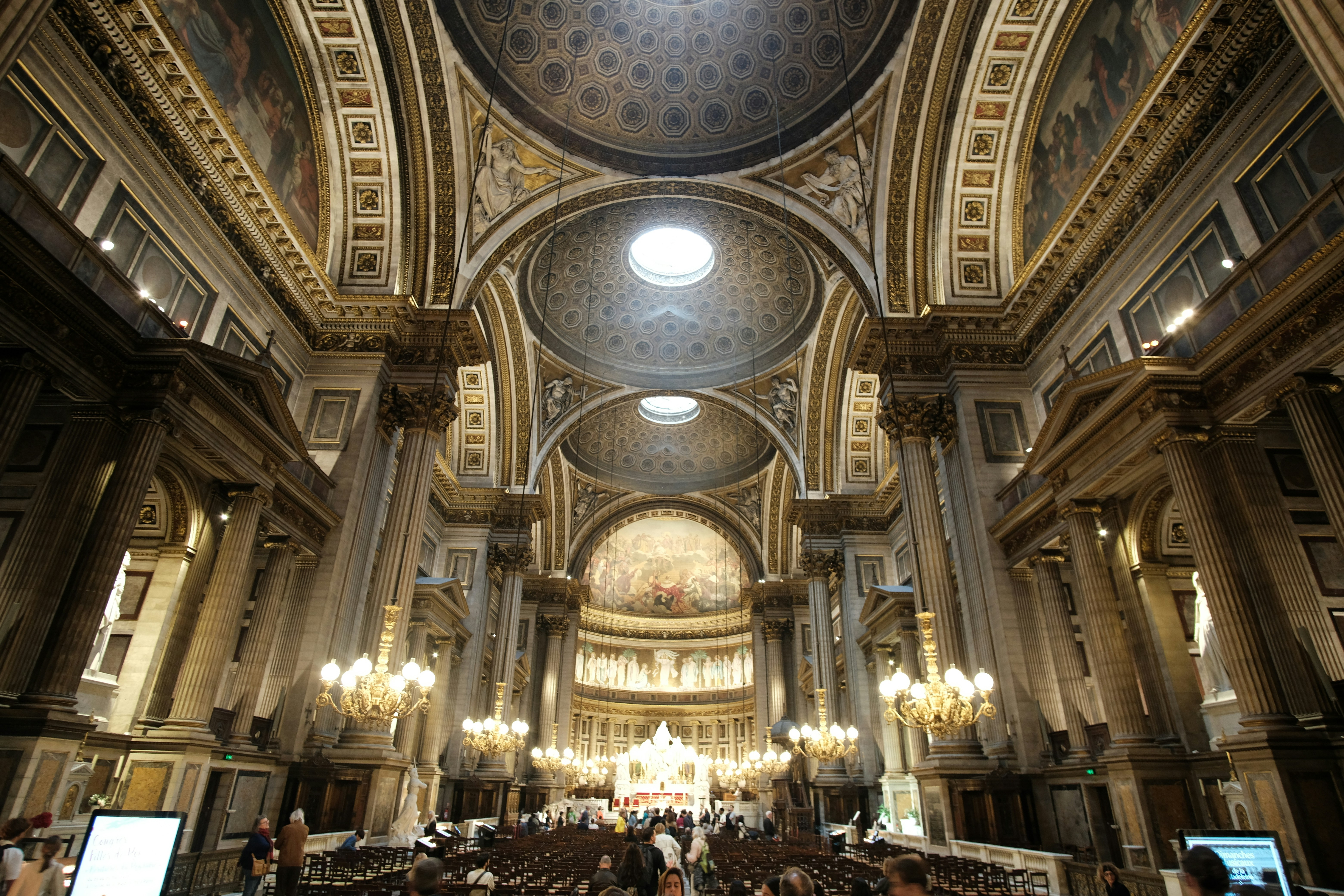 Innenraum einer prächtigen Kathedrale mit kunstvoller Architektur und Kronleuchtern.