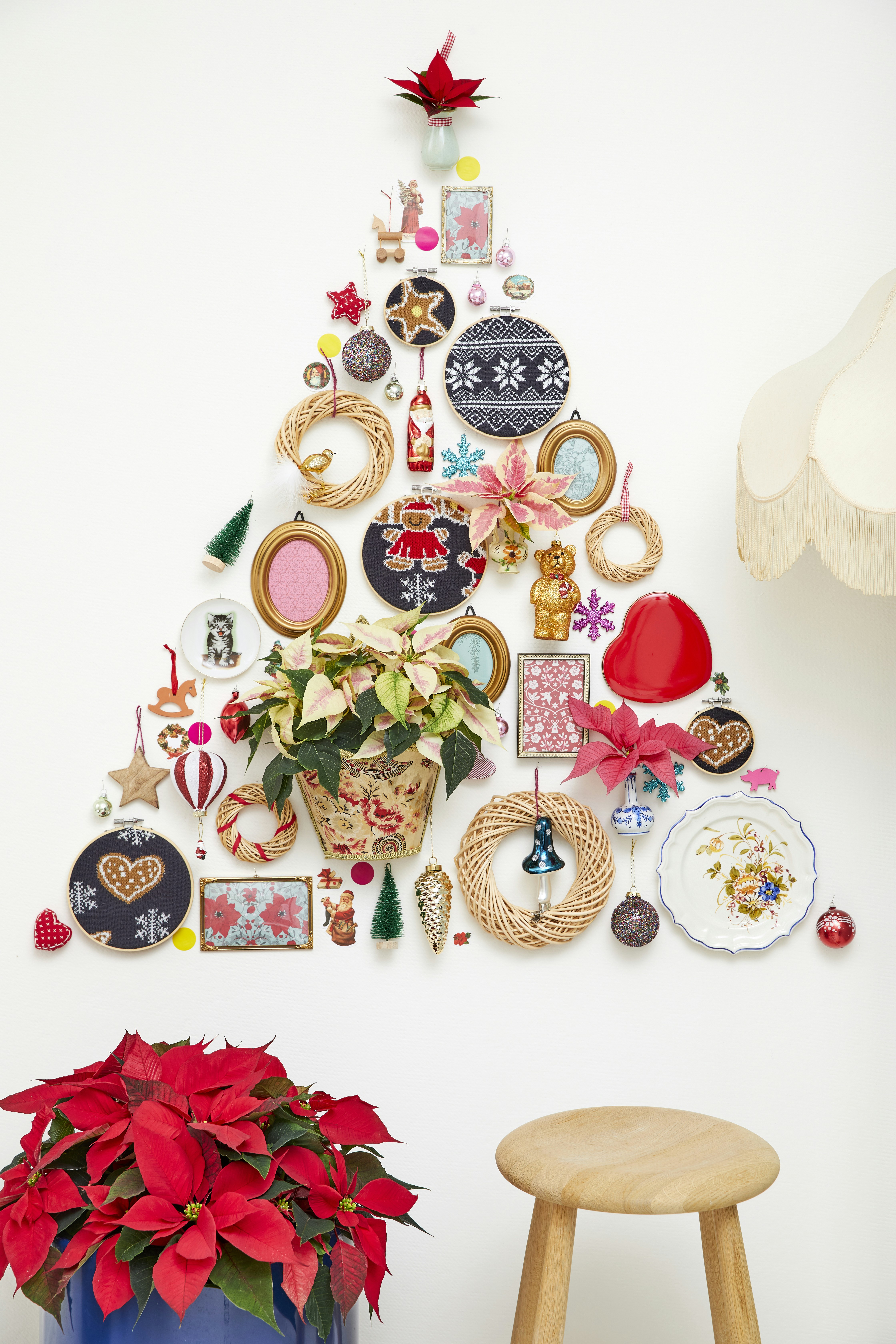 Christmas tree made of ornaments and decorations on wall.