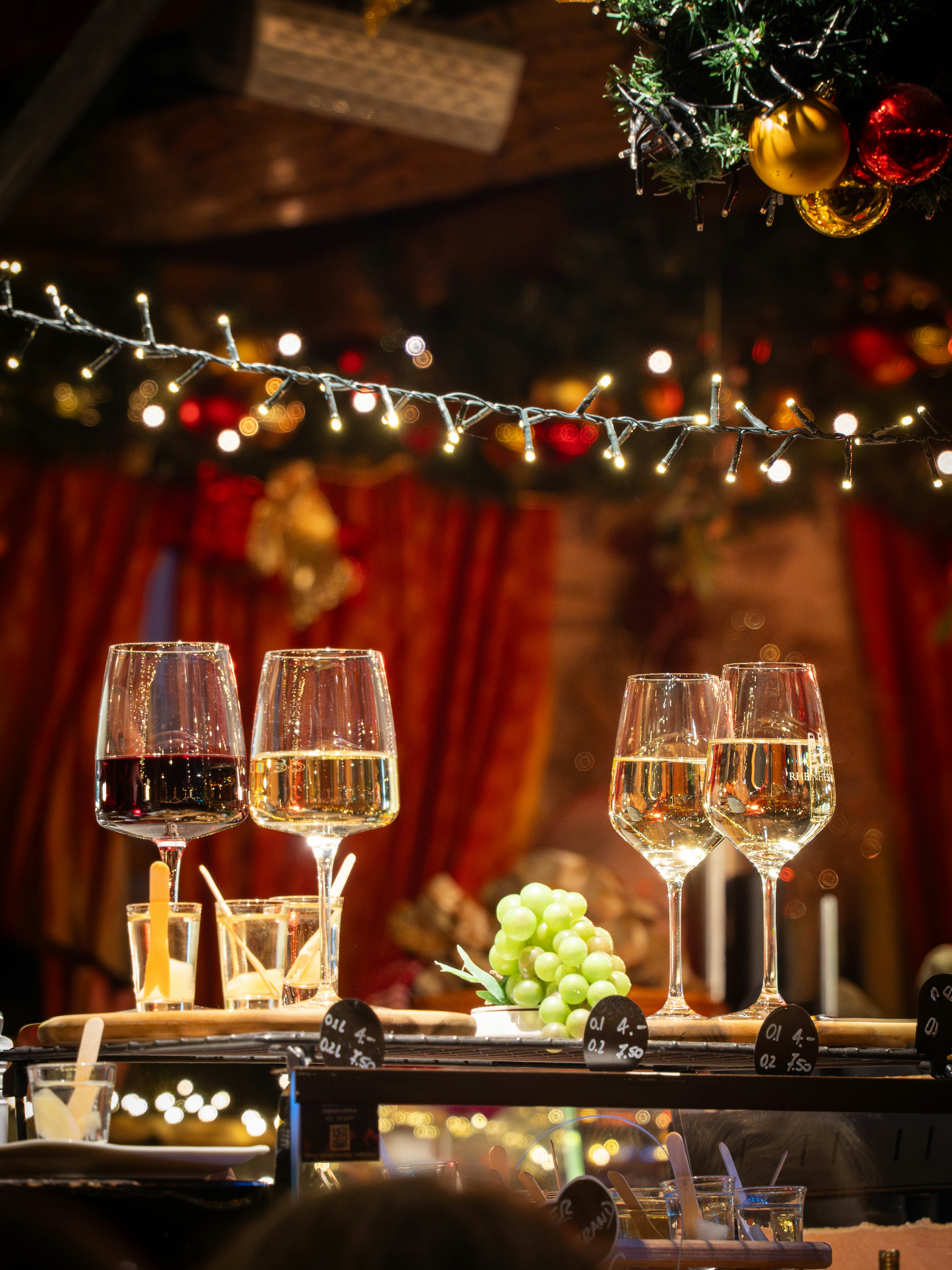 Glasses of wine and grapes with festive lights