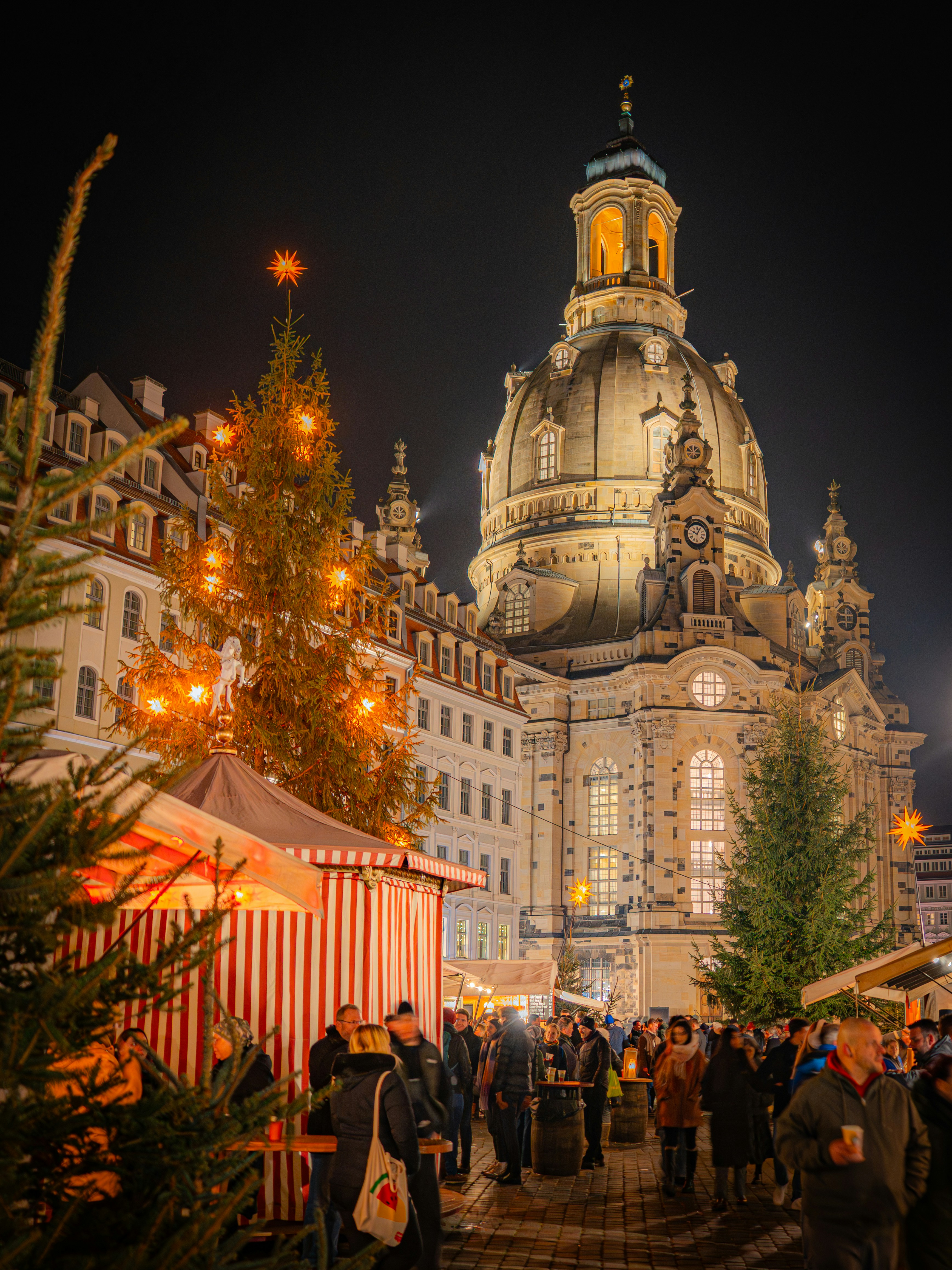 Christmas market with decorated tree and church at night