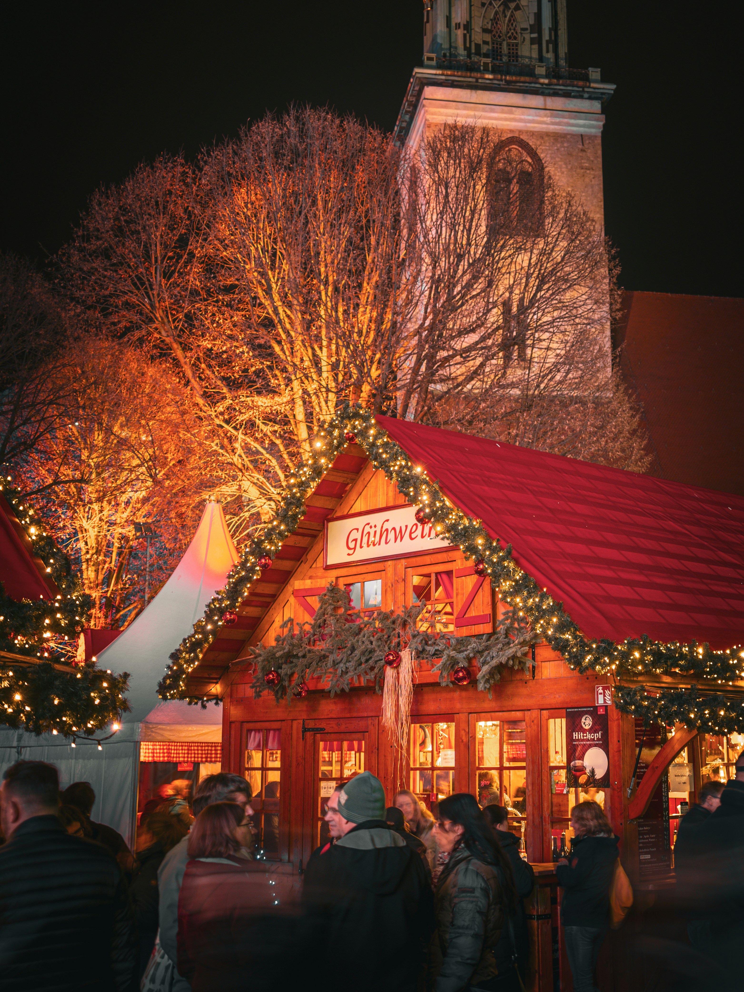 Christmas market stalls with festive lights at night