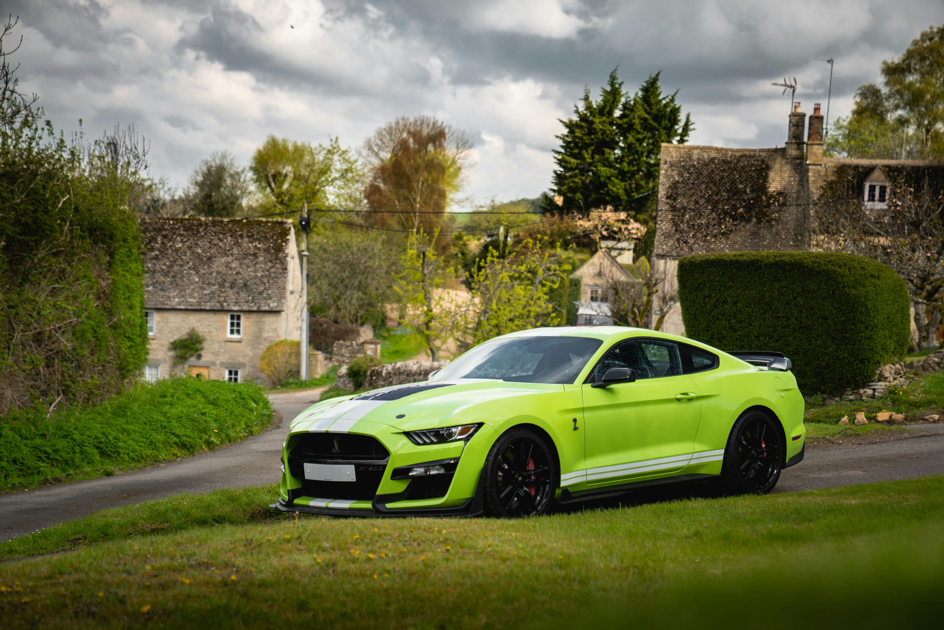 A bright green sports car parked on a grassy road.