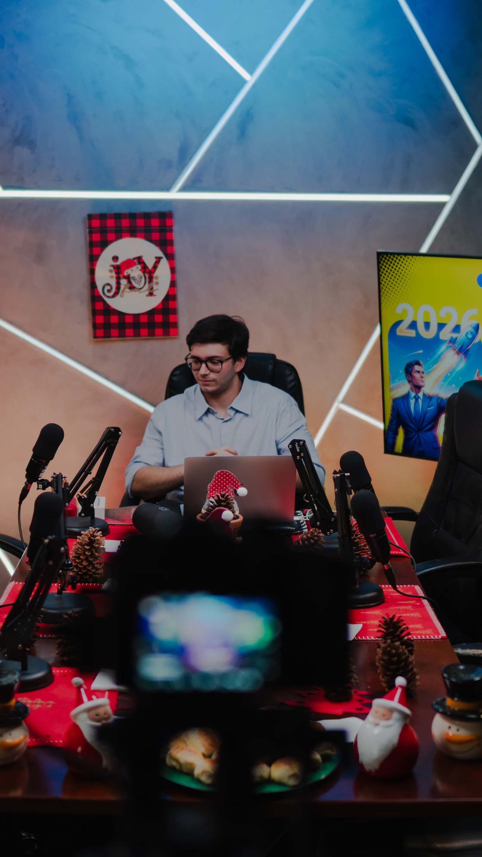 Creator working at a desk with studio microphones and a laptop