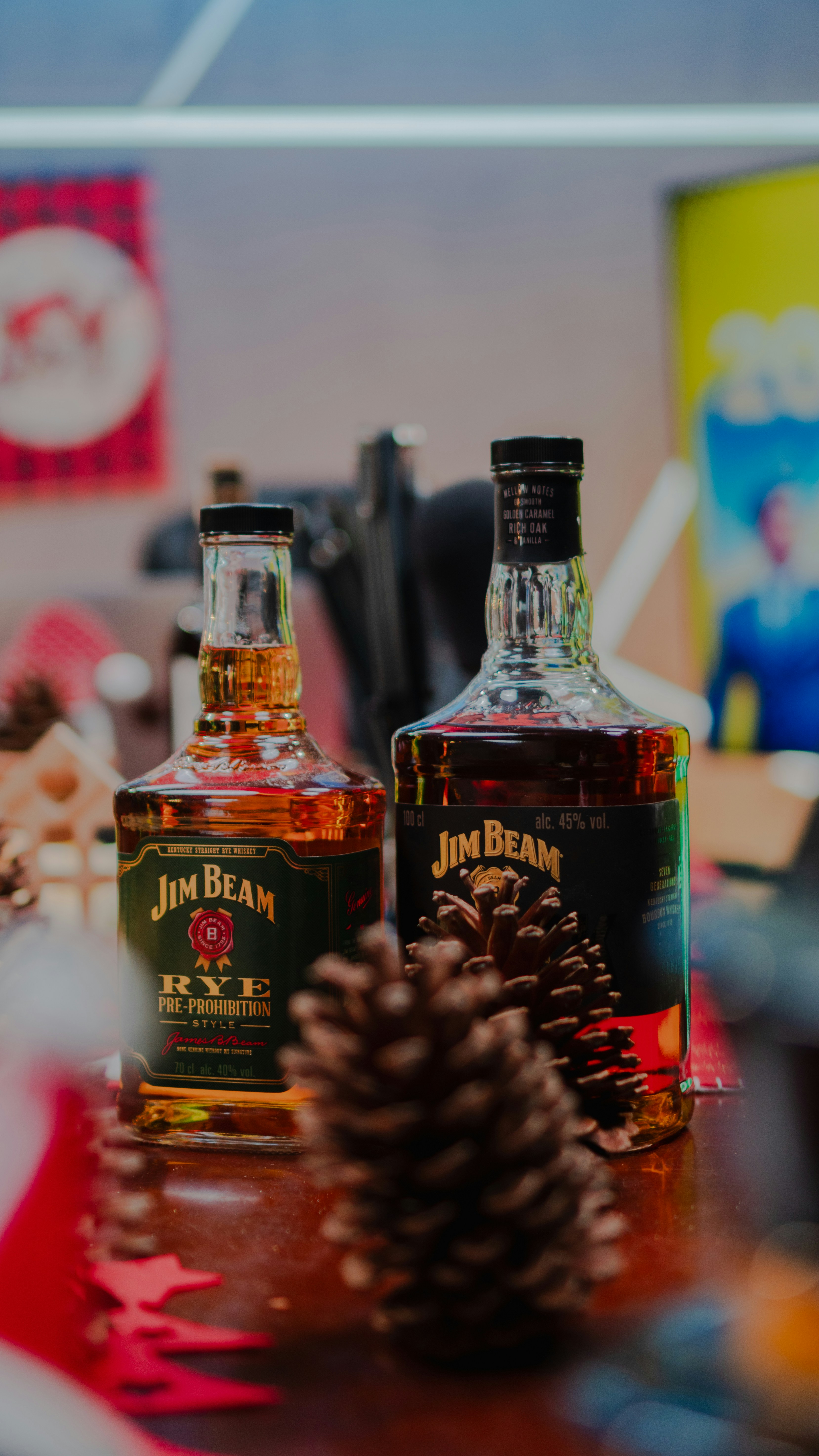Due bottiglie di whiskey jim beam con pigne