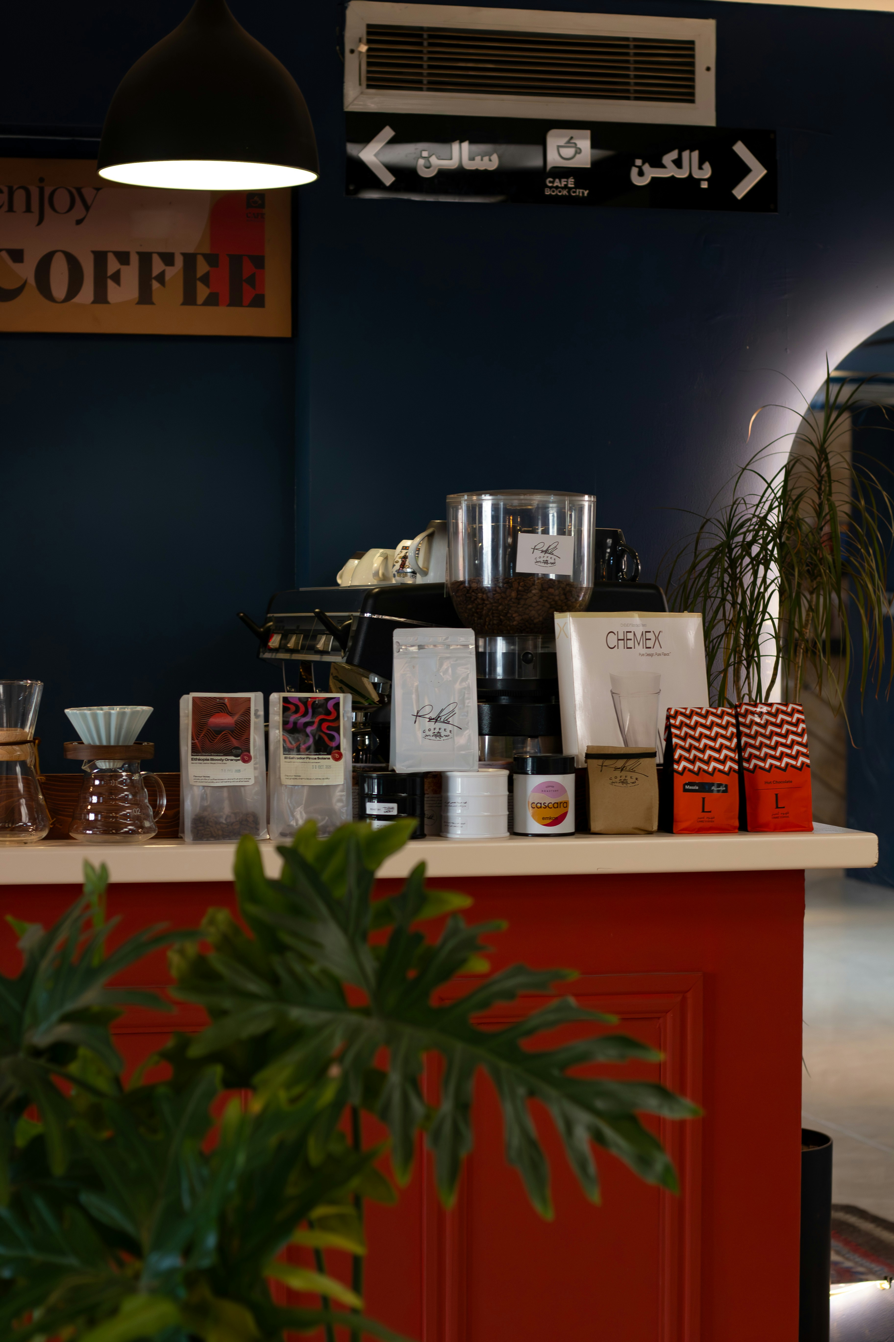 Kaffeetheke mit Espressomaschine und verpacktem Kaffee.