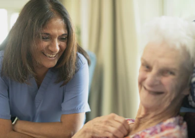 Nurse smiling with elderly patient in room