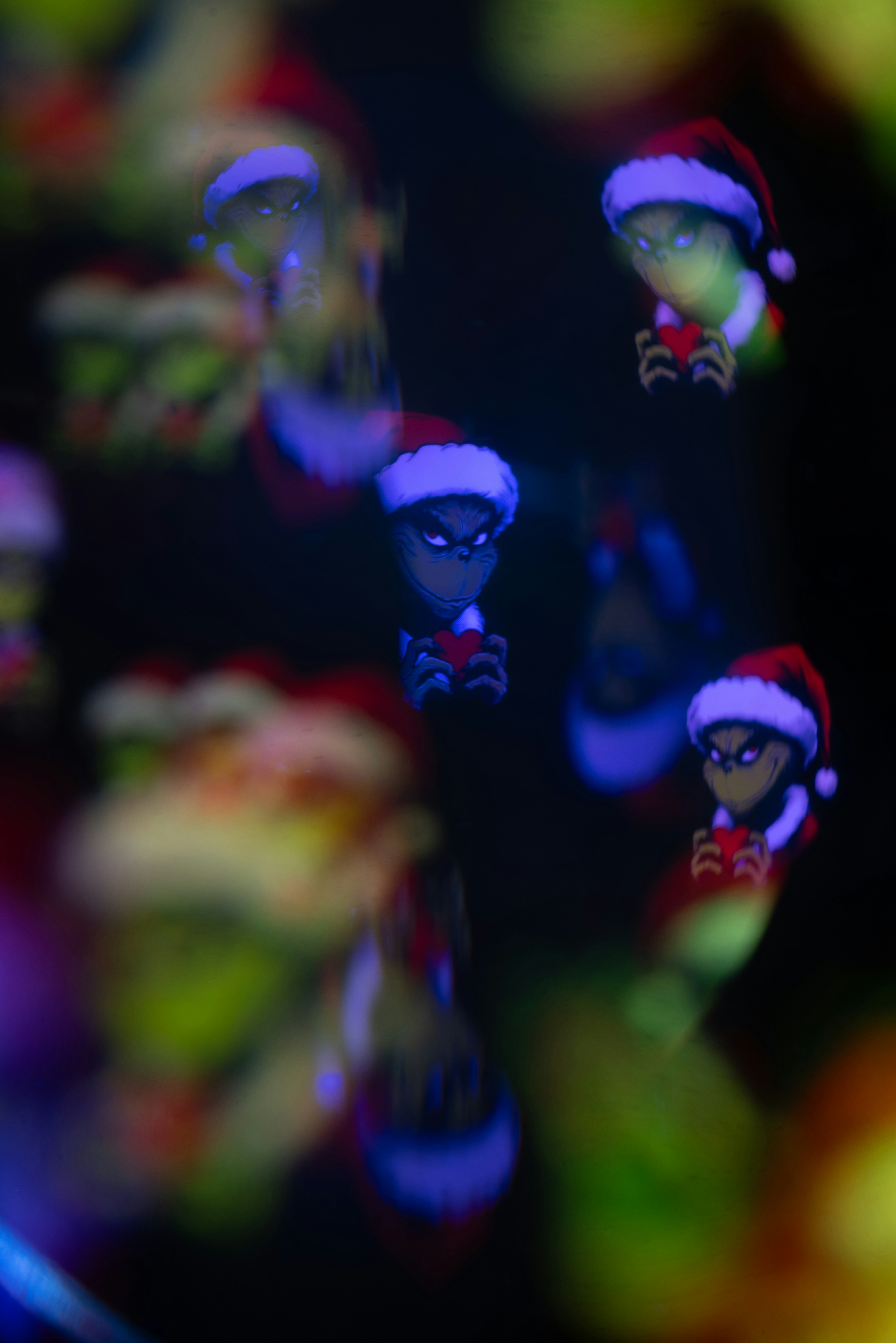 Grinch characters wearing santa hats with bokeh effect.