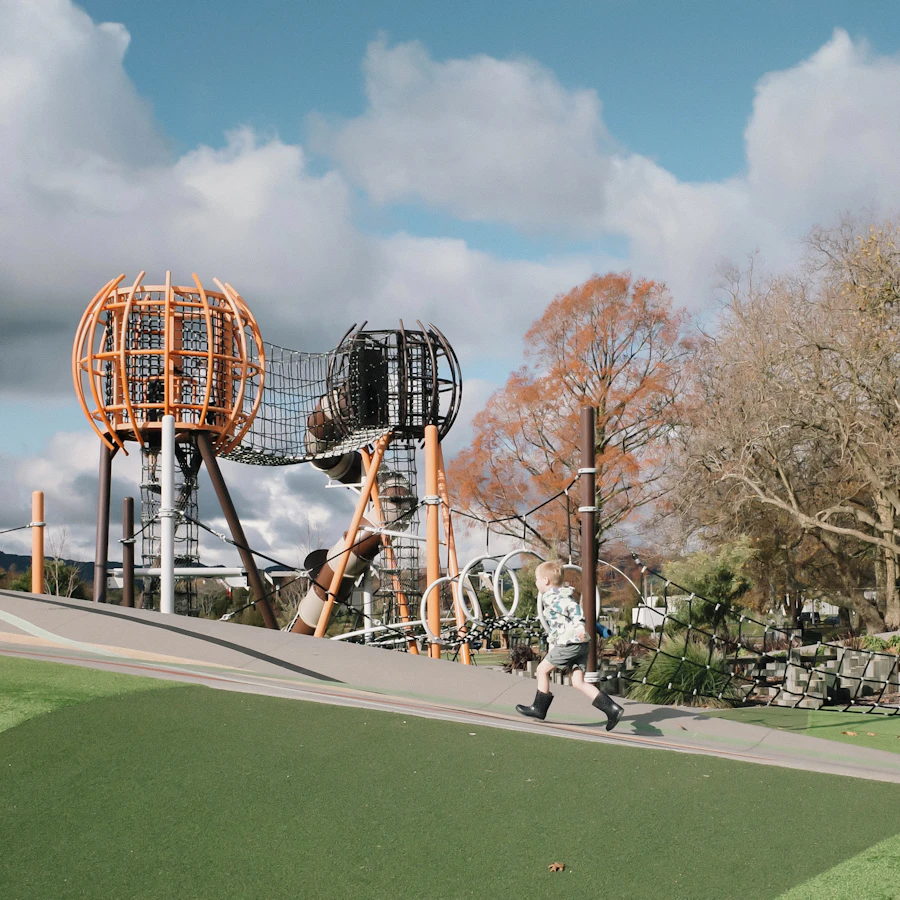 A child running happily toward playground equipment on a sunny day