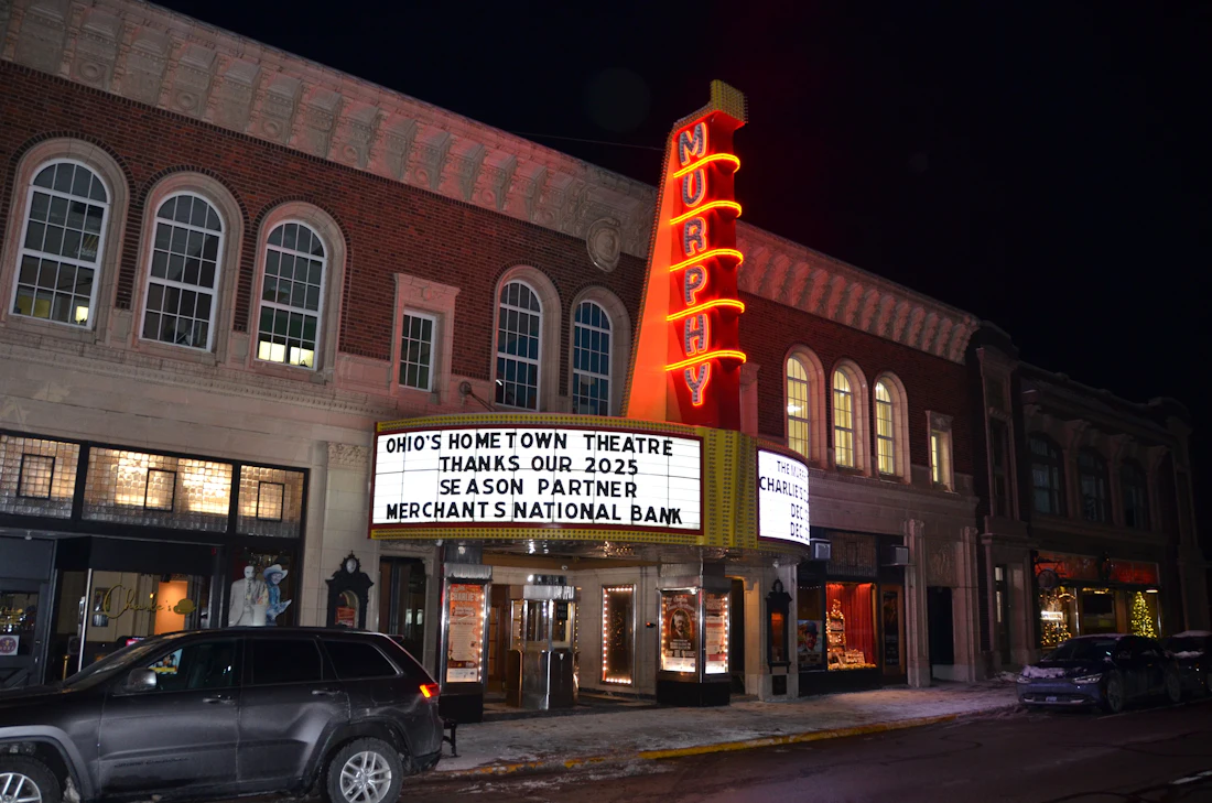 A small theatre marquee glowing at night