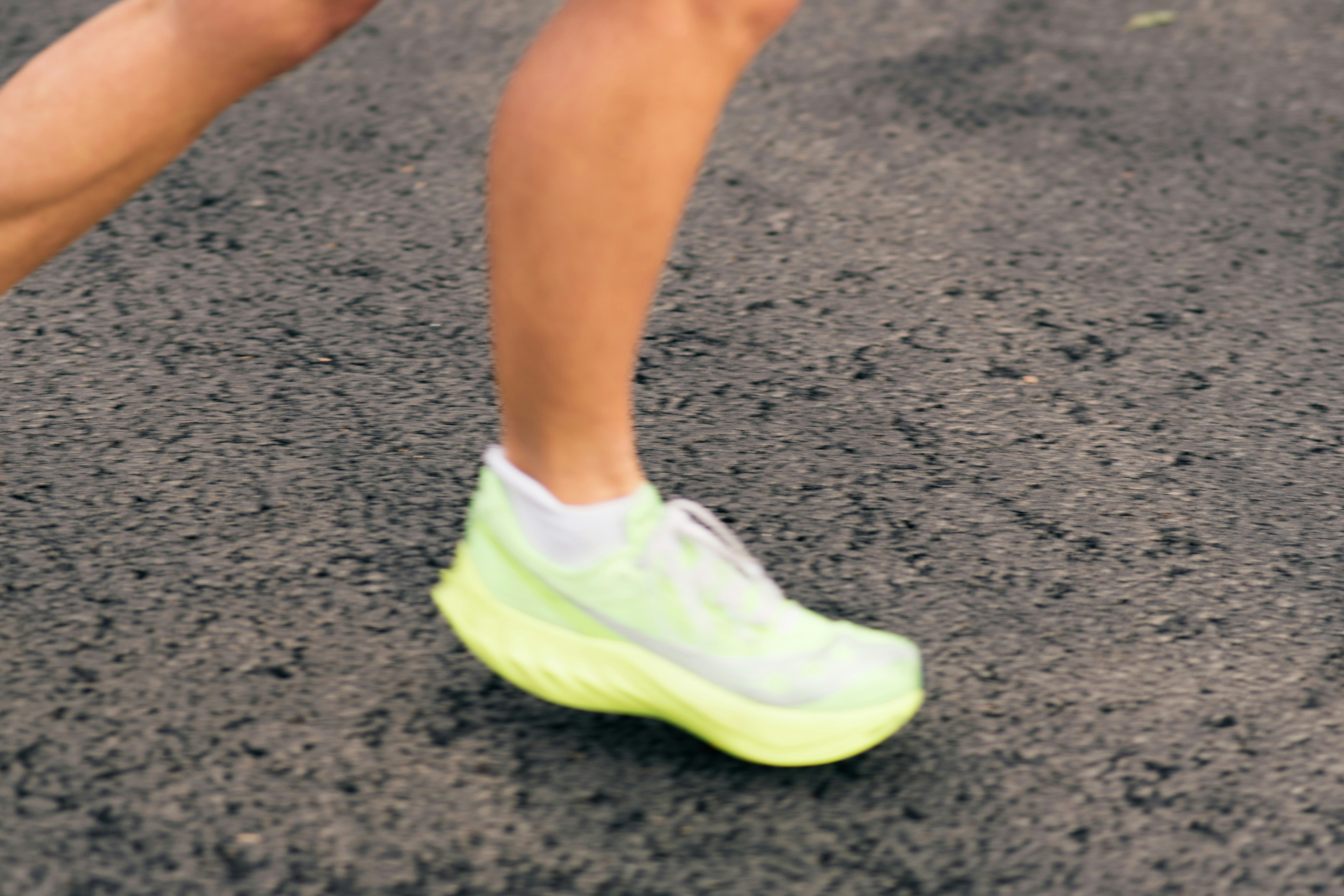 Runner's foot in a neon green shoe on pavement