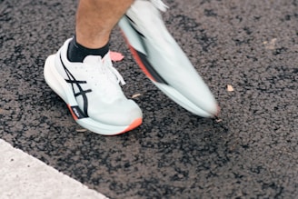 Runner's feet in white athletic shoes on pavement