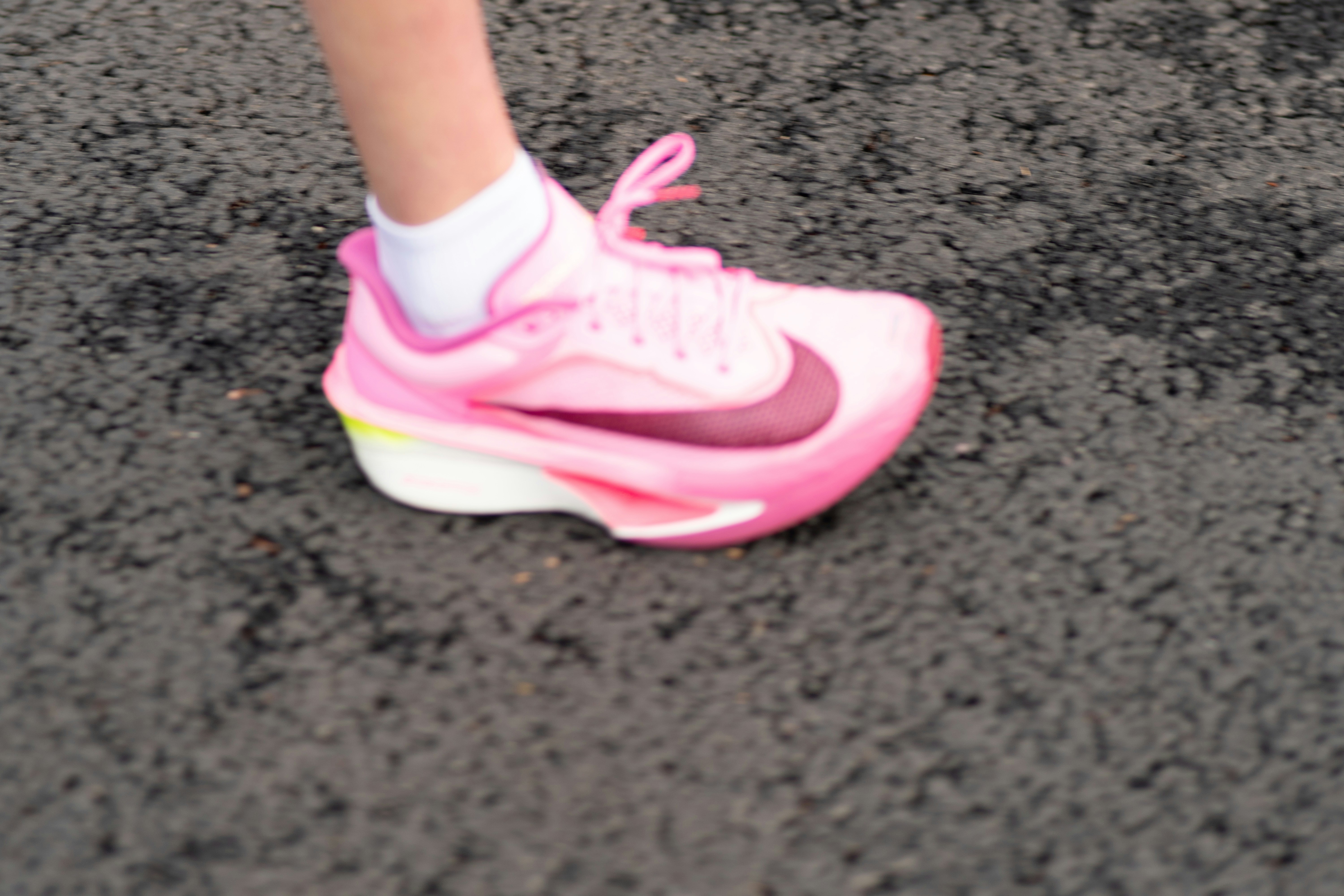 Pink athletic shoe on dark surface