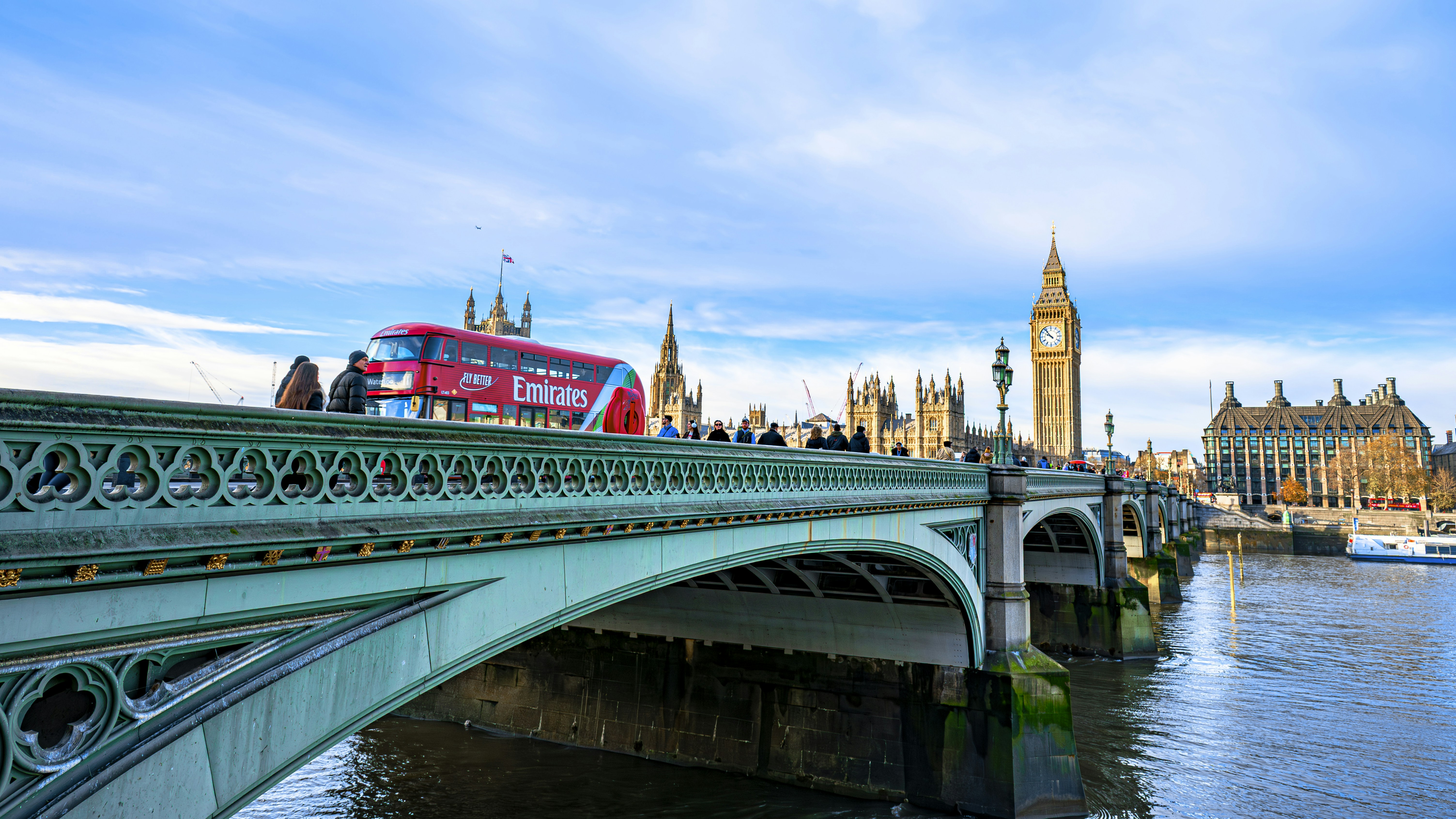 Red double-decker bus crossing westminster bridge, london.