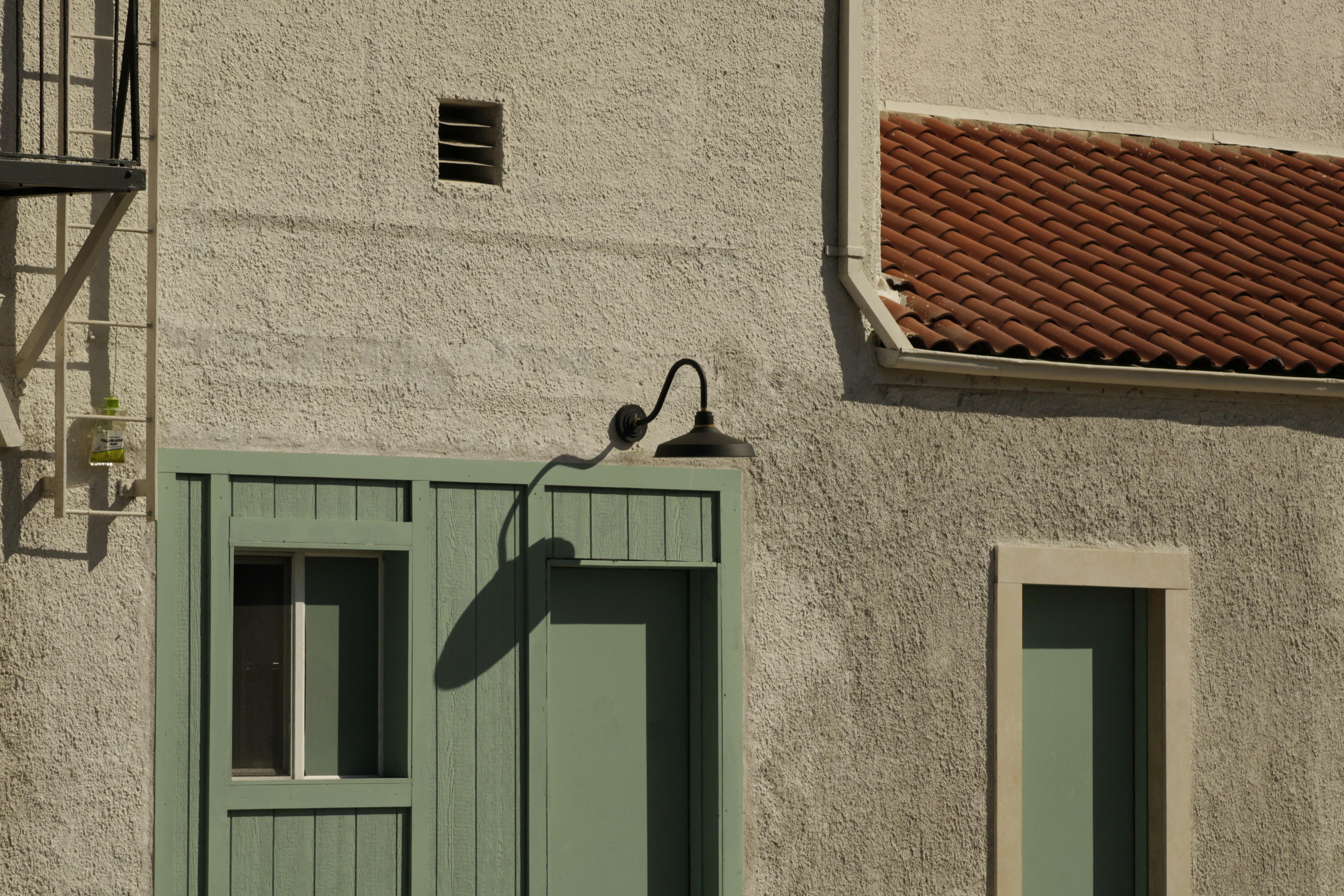 Light fixture above a pale green door and window.