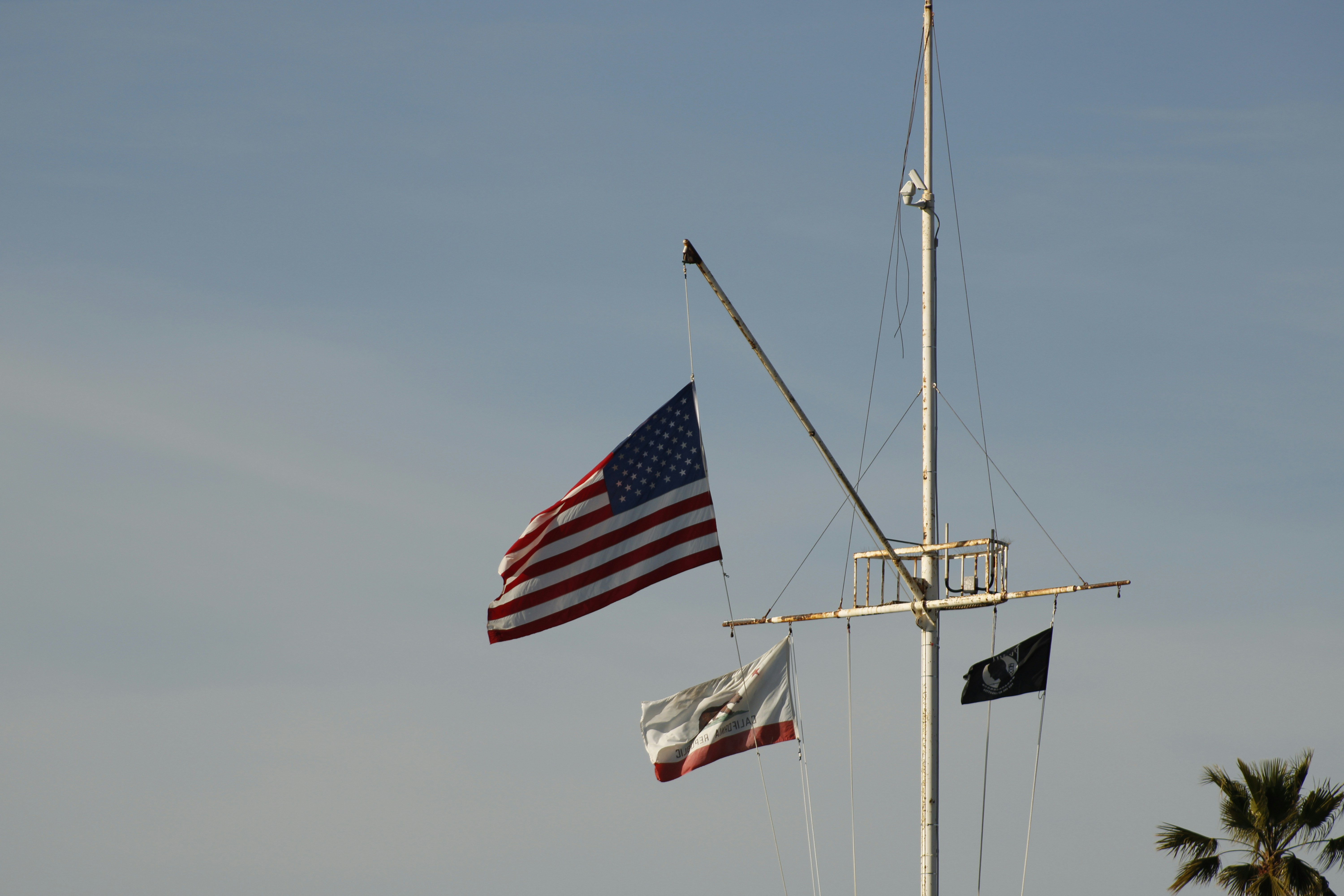 American and california flags fly on mast.