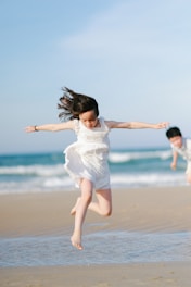 Children jumping and playing on a sunny beach.
