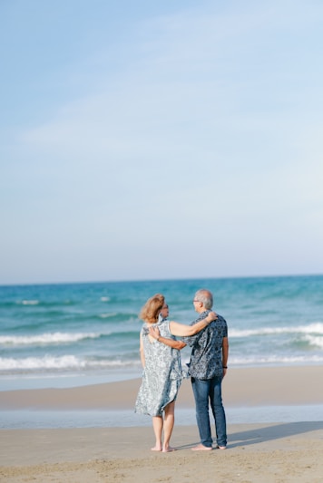 Couple standing on beach looking at ocean