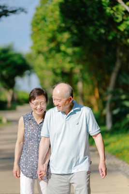 Elderly couple holding hands while walking outdoors