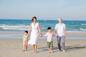 Family walking on a beach holding hands