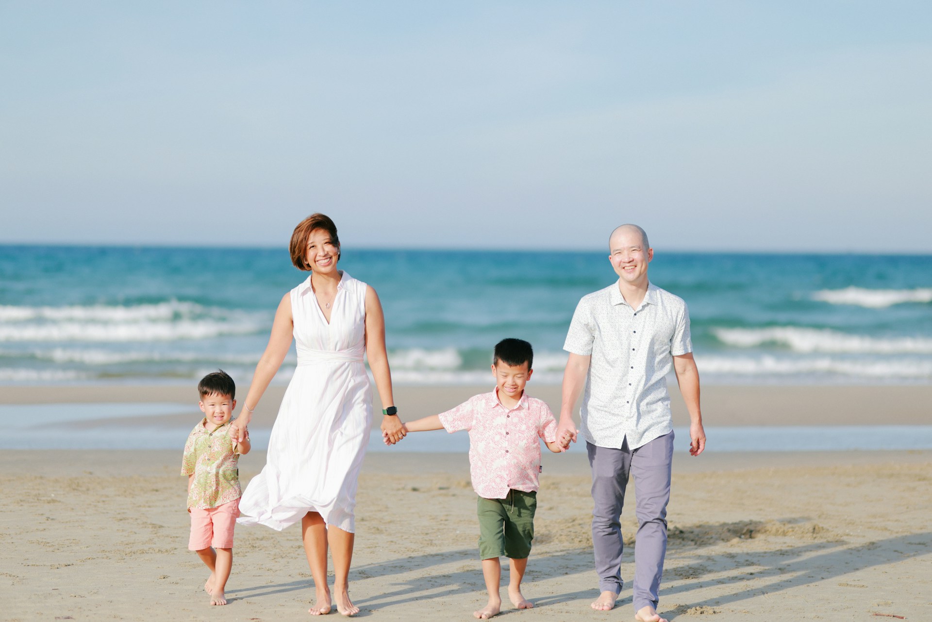 Family walking on beach with ocean background