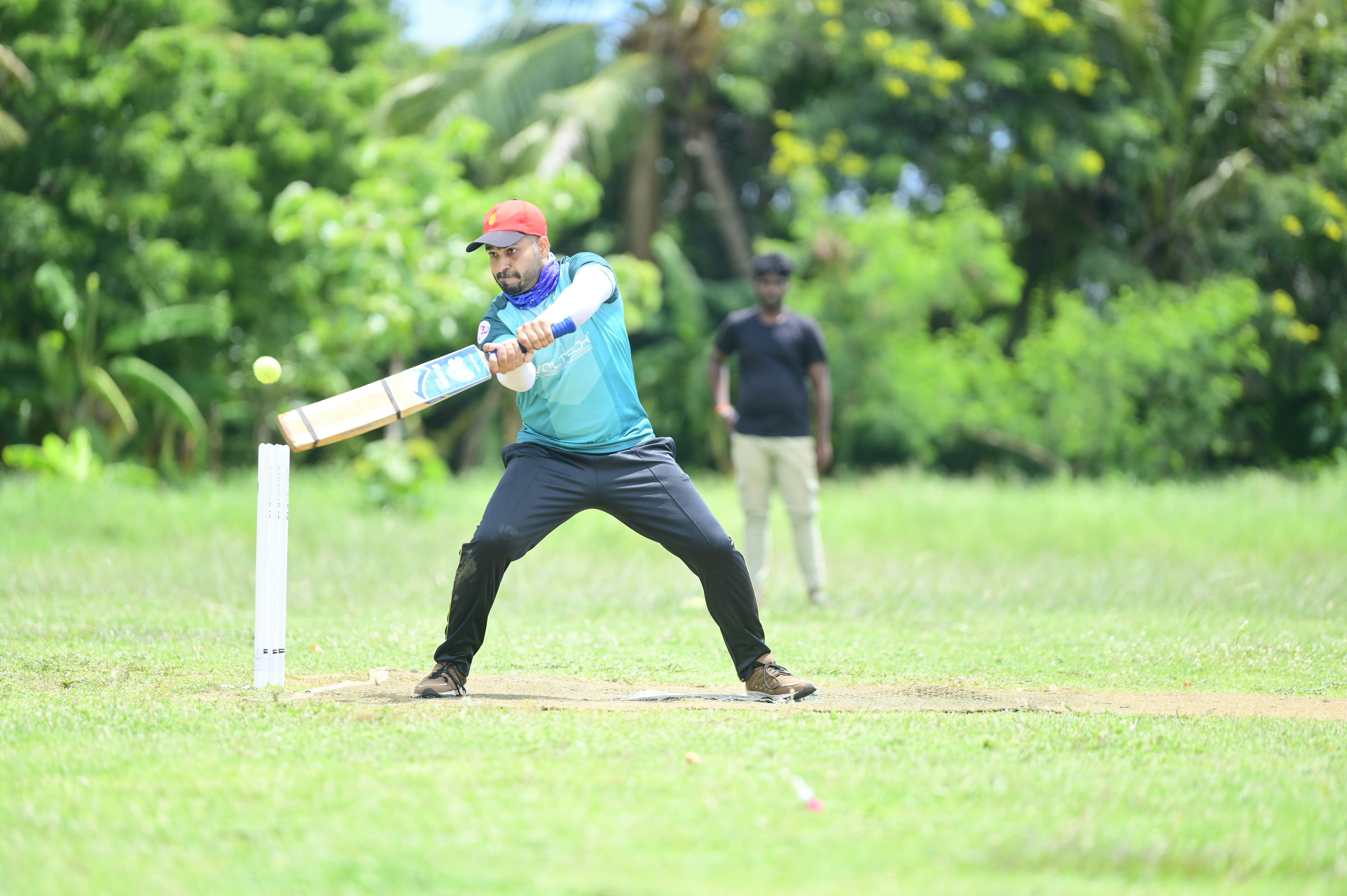 A man playing cricket on a grassy field.