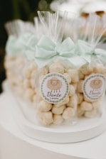 Party favors with sheep stickers and mint bows.