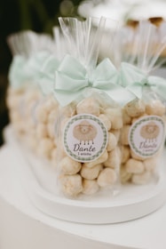 Party favors with sheep stickers and mint bows.