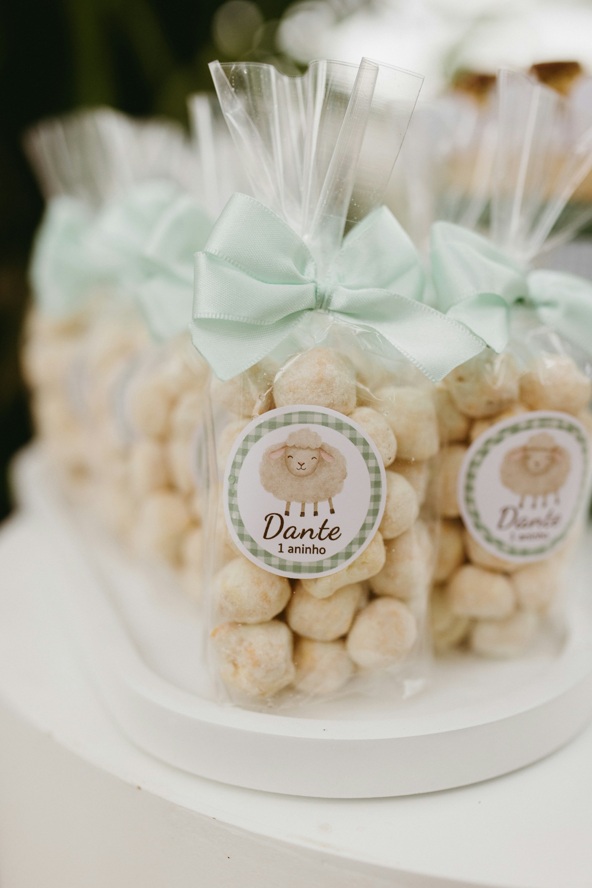 Party favors with sheep stickers and mint bows.