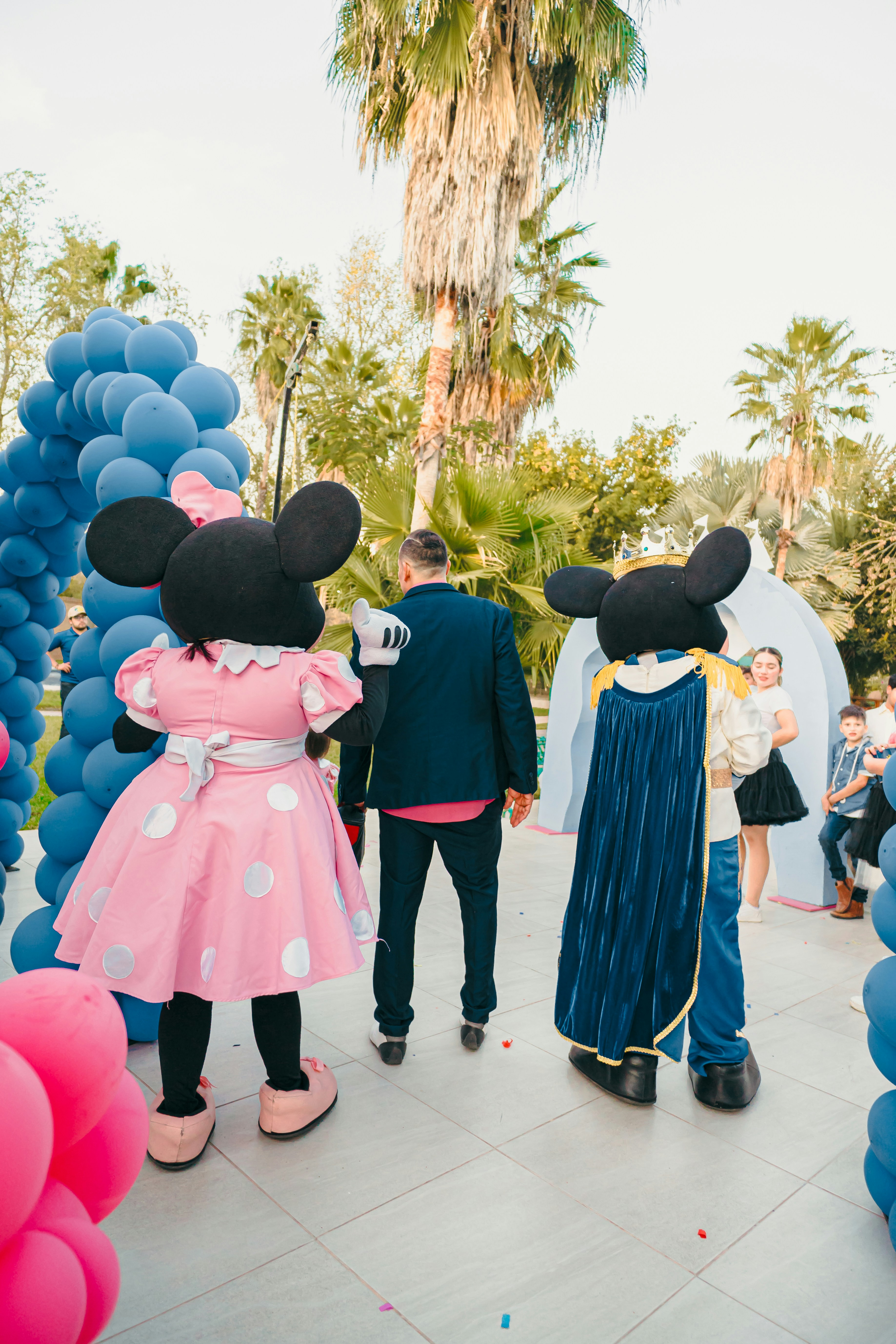 Minnie mouse and prince charming greet guests outdoors