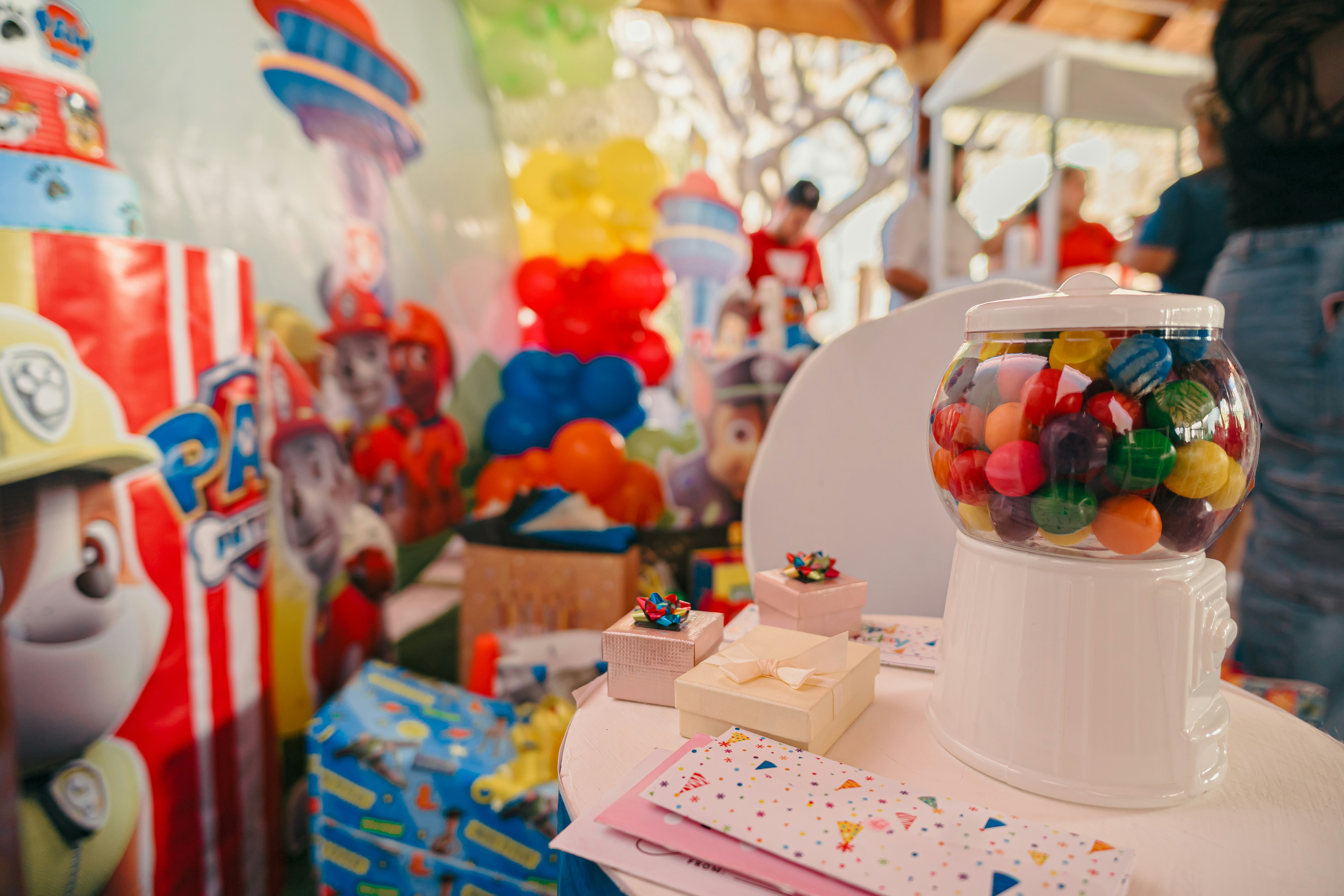 Birthday party decorations with gumball machine and cakes