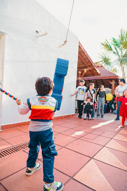 Boy hitting piñata with stick at party