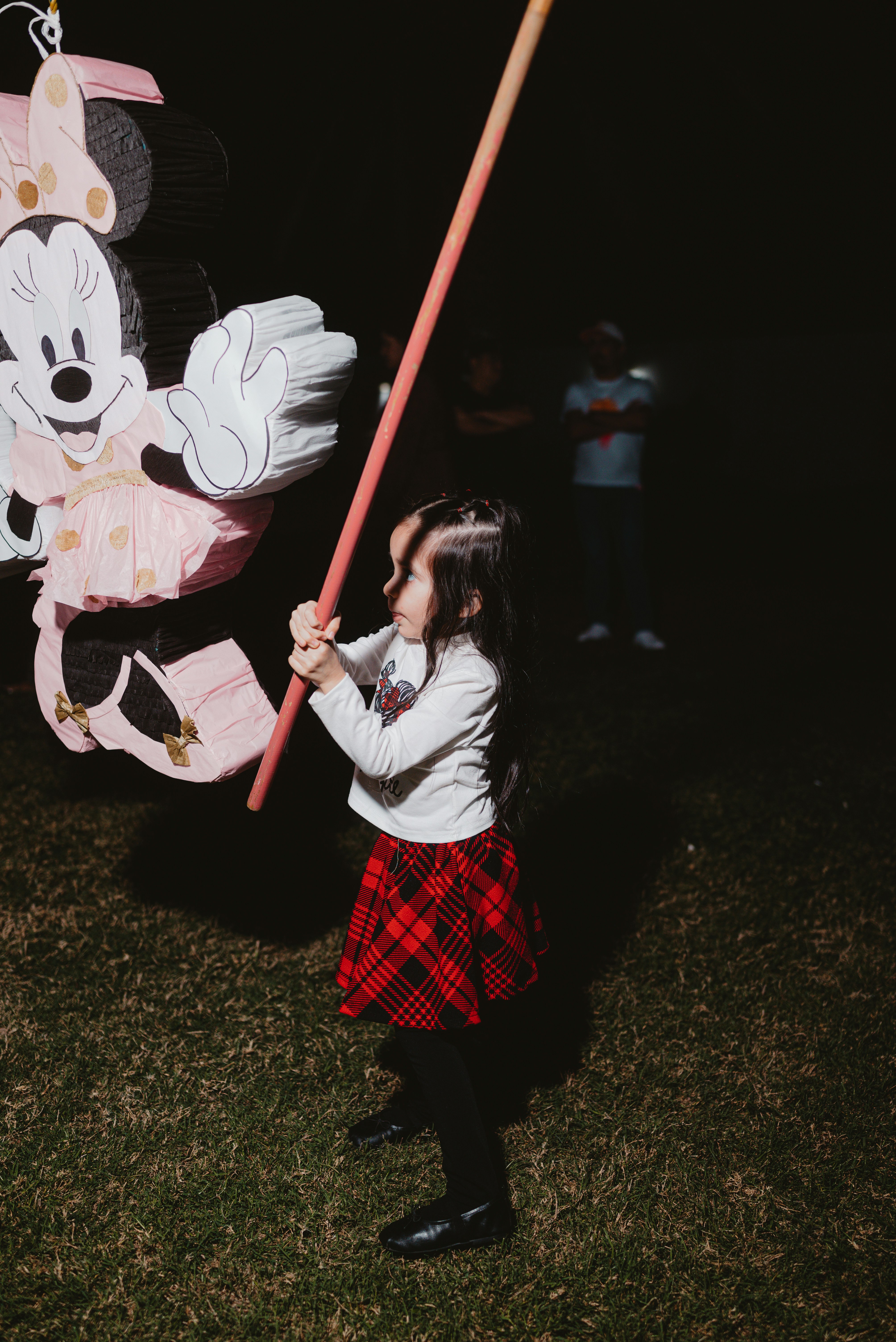 Fillette s'amusant à frapper une piñata colorée