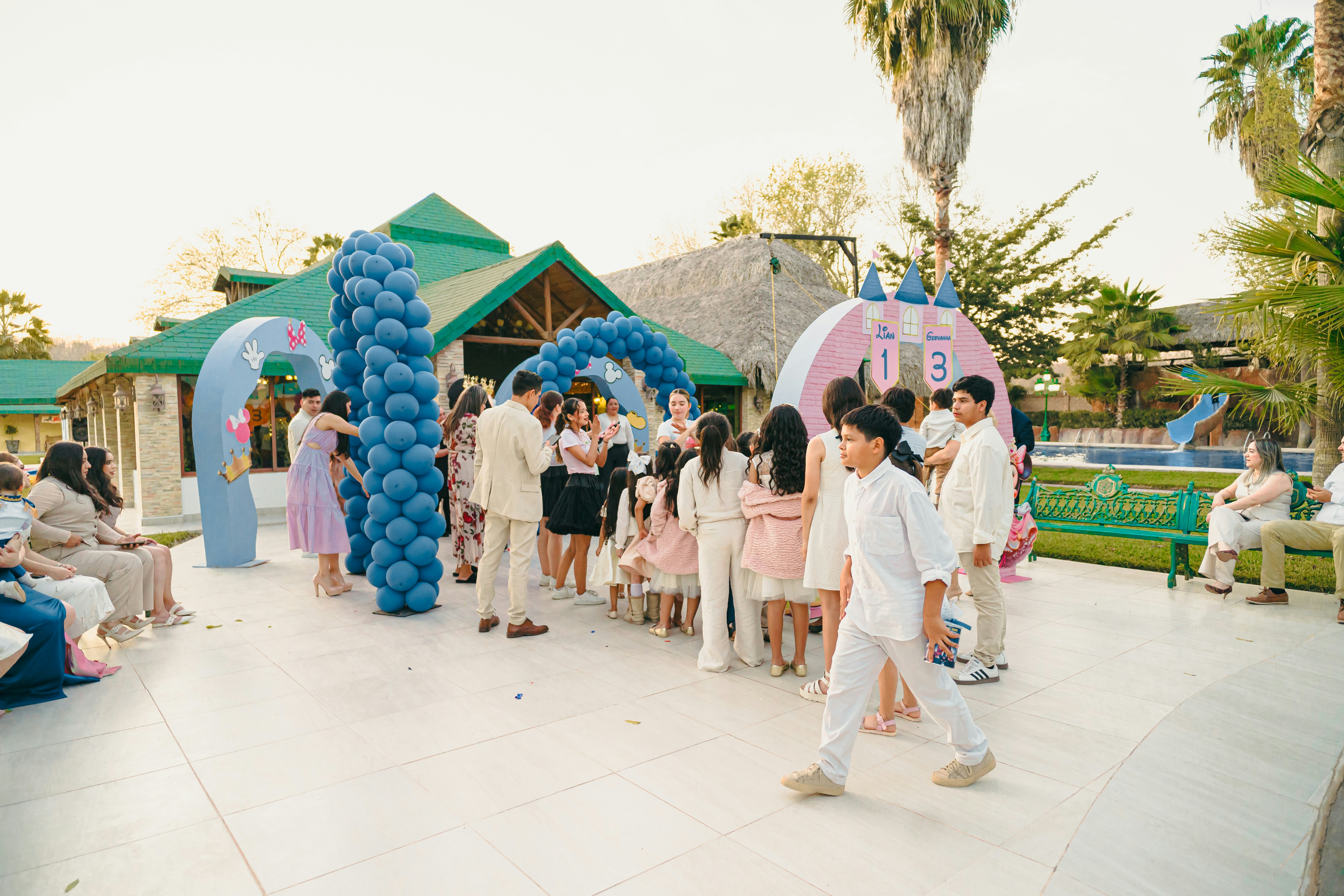 Children and adults at a party with balloon decorations.
