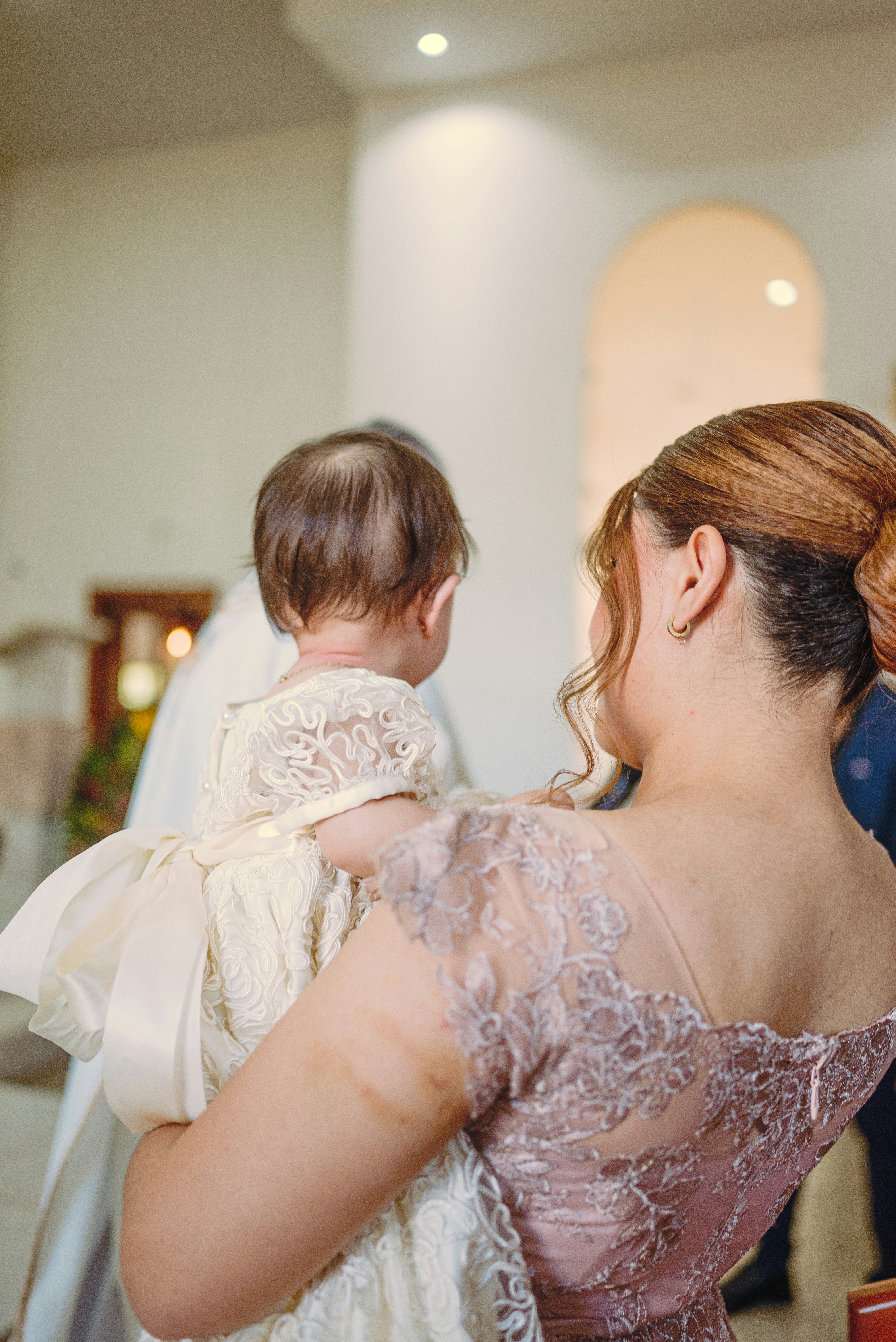 Mama trzymająca dziecko w białej sukience