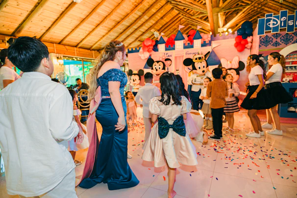 Children in disney costumes at a party with confetti.