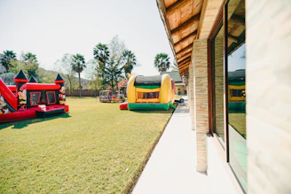 Two inflatable bounce houses on a grassy lawn.