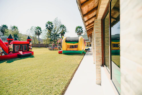 Two inflatable bounce houses on a grassy lawn.
