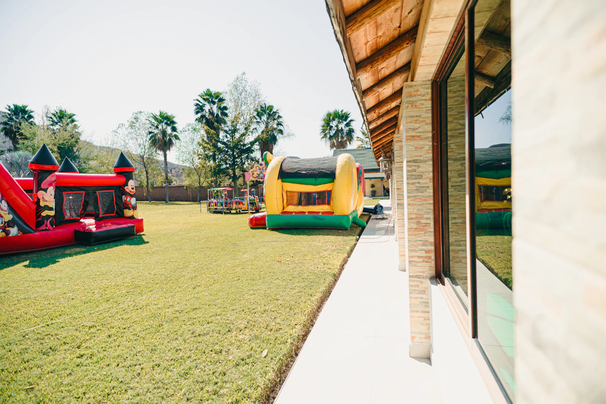 Two inflatable bounce houses on a grassy lawn