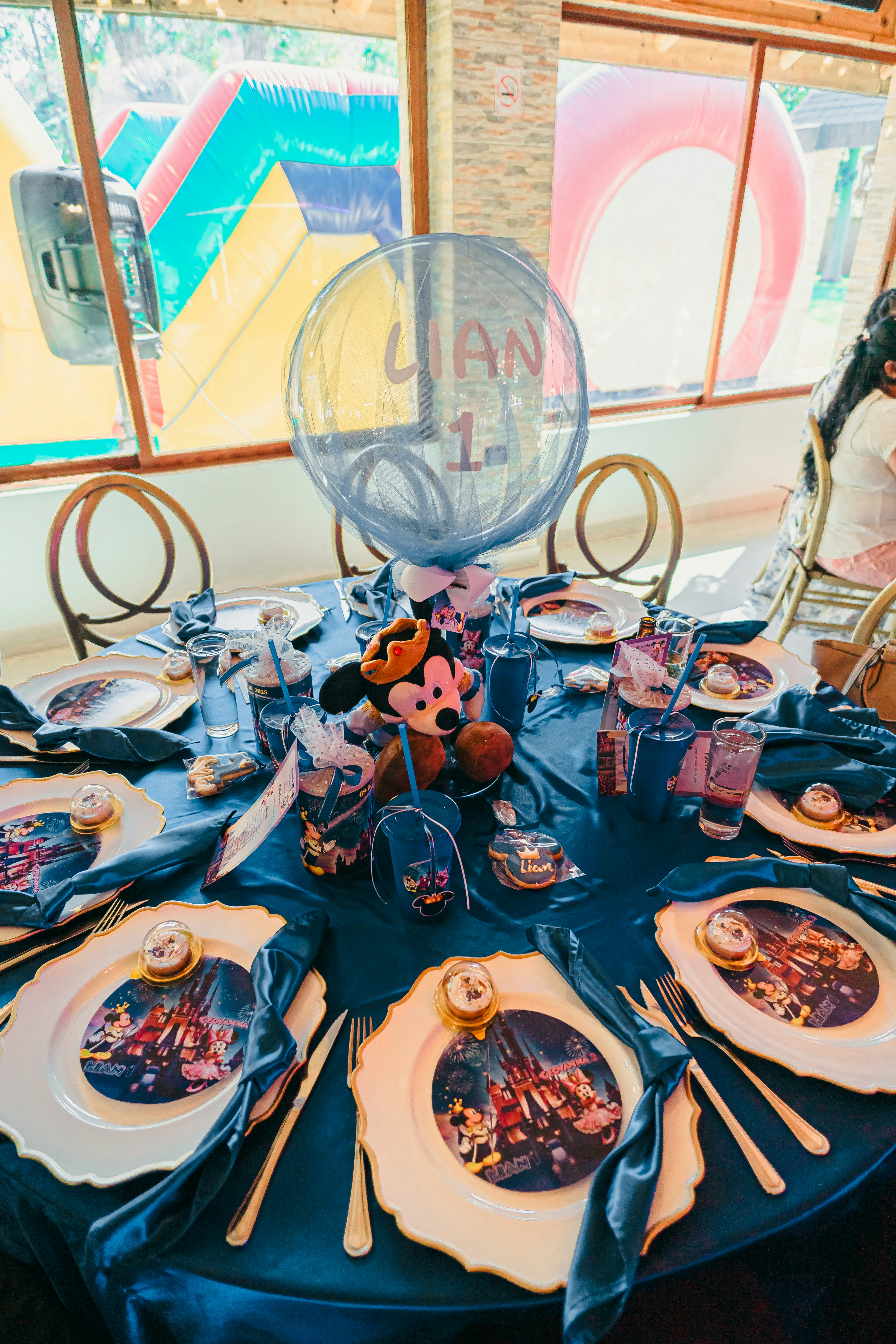 Una mesa de cumpleaños con temática Disney y decoraciones de mickey mouse.