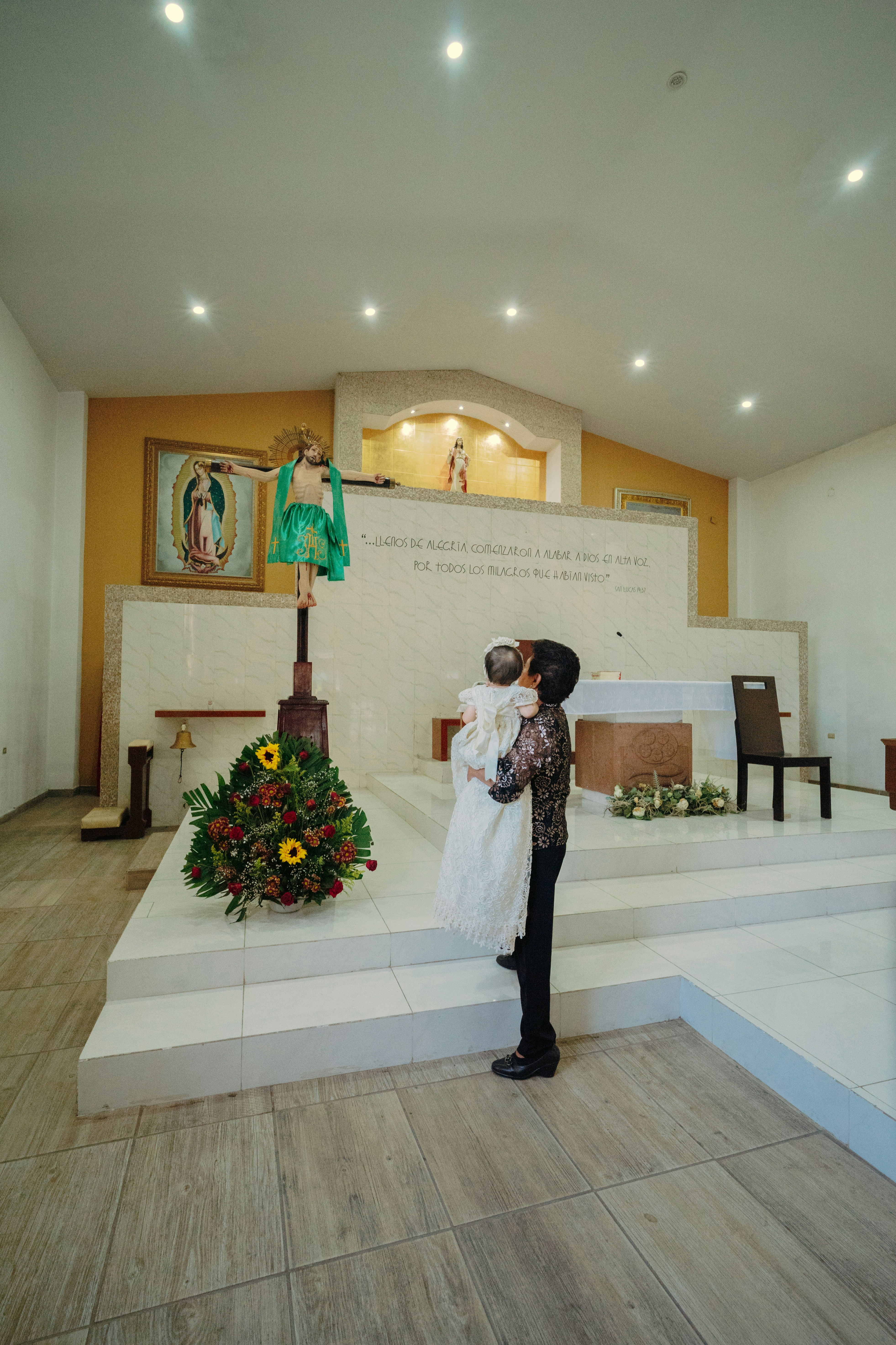 Person holding a baby in a church altar.