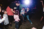 Children and adult dancing outdoors at night