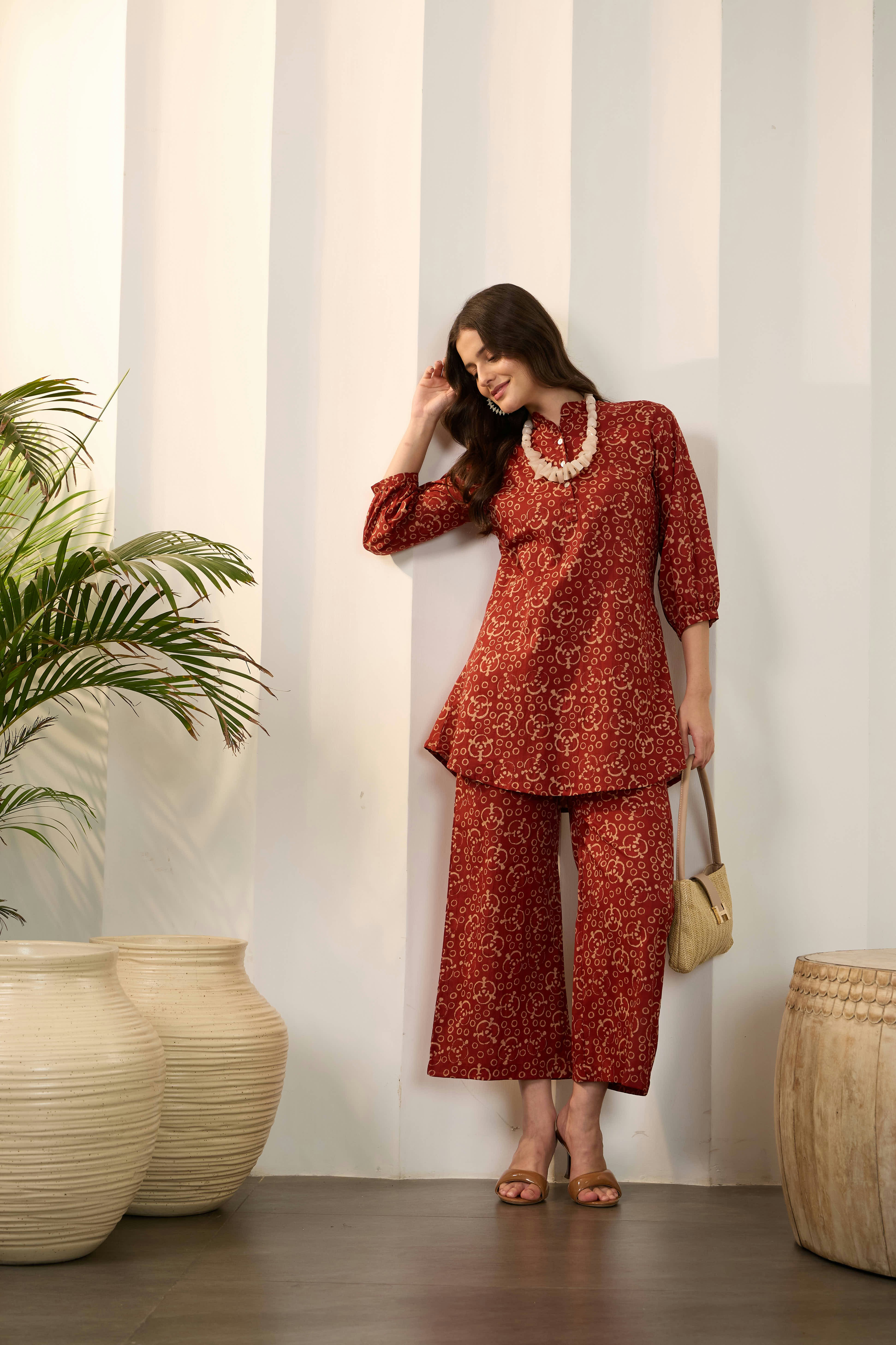 Woman in leopard print outfit with necklace and handbag.