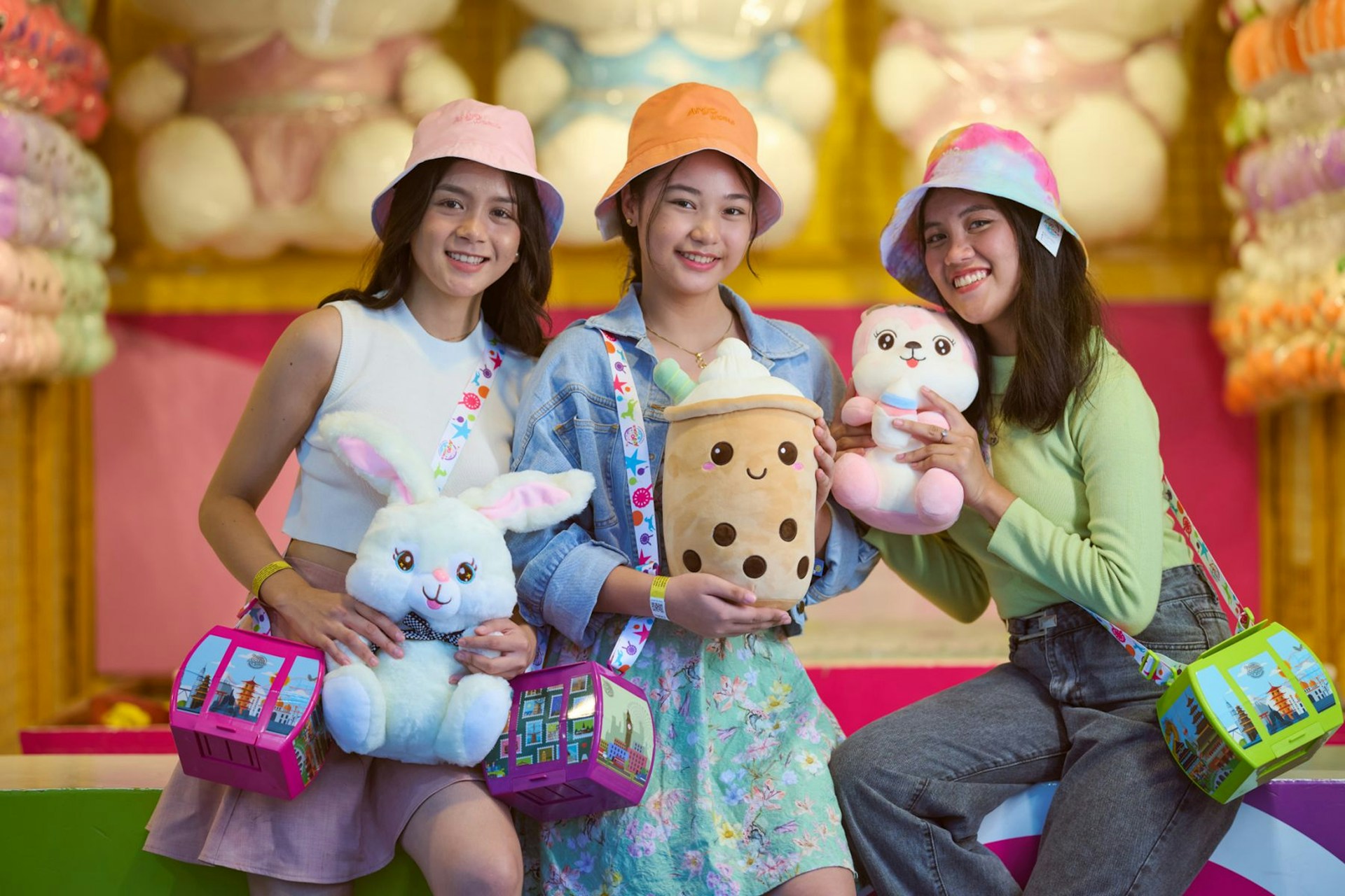 Three friends holding plush toys and bags