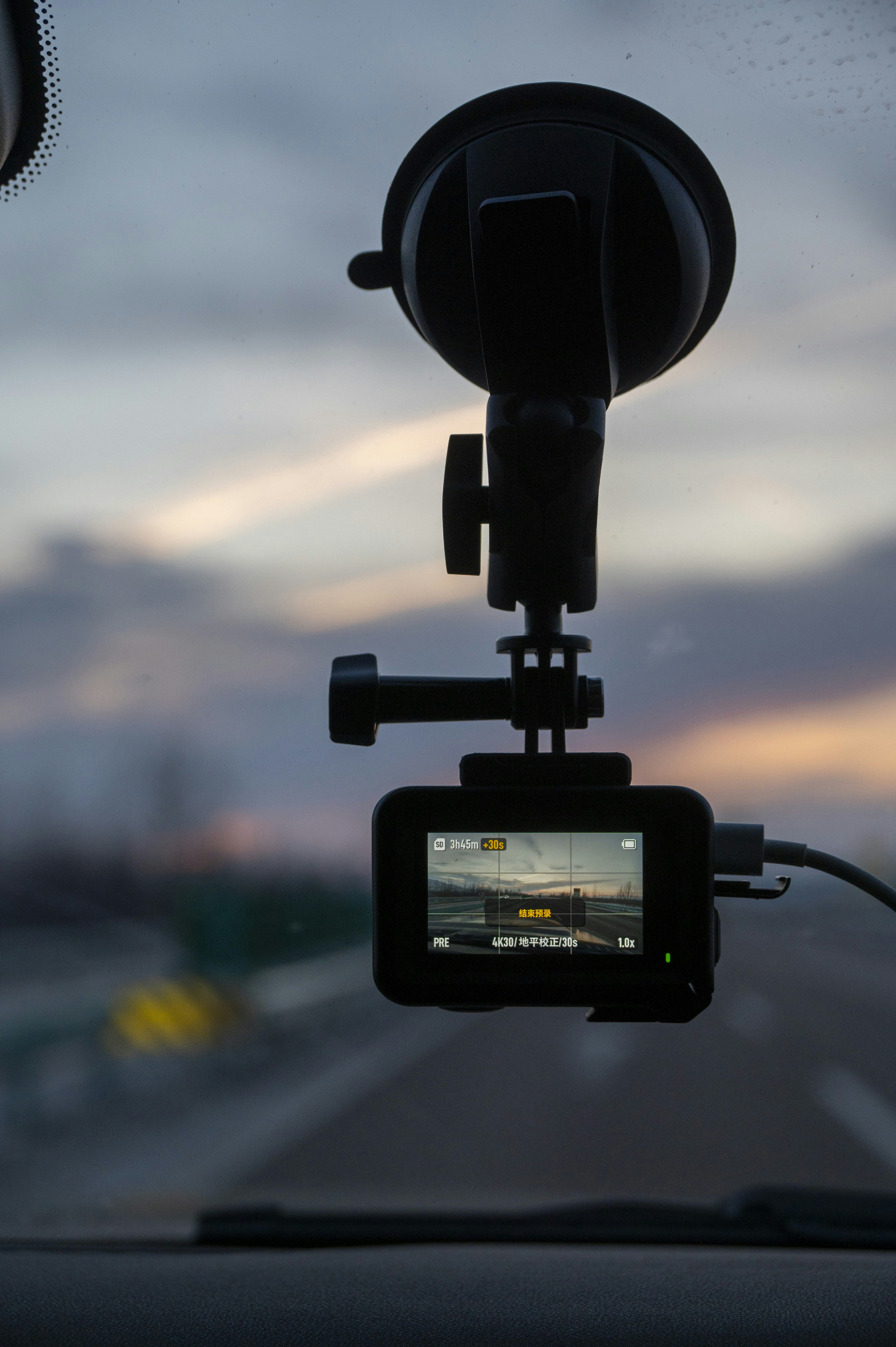 Action camera mounted on car windshield at sunset